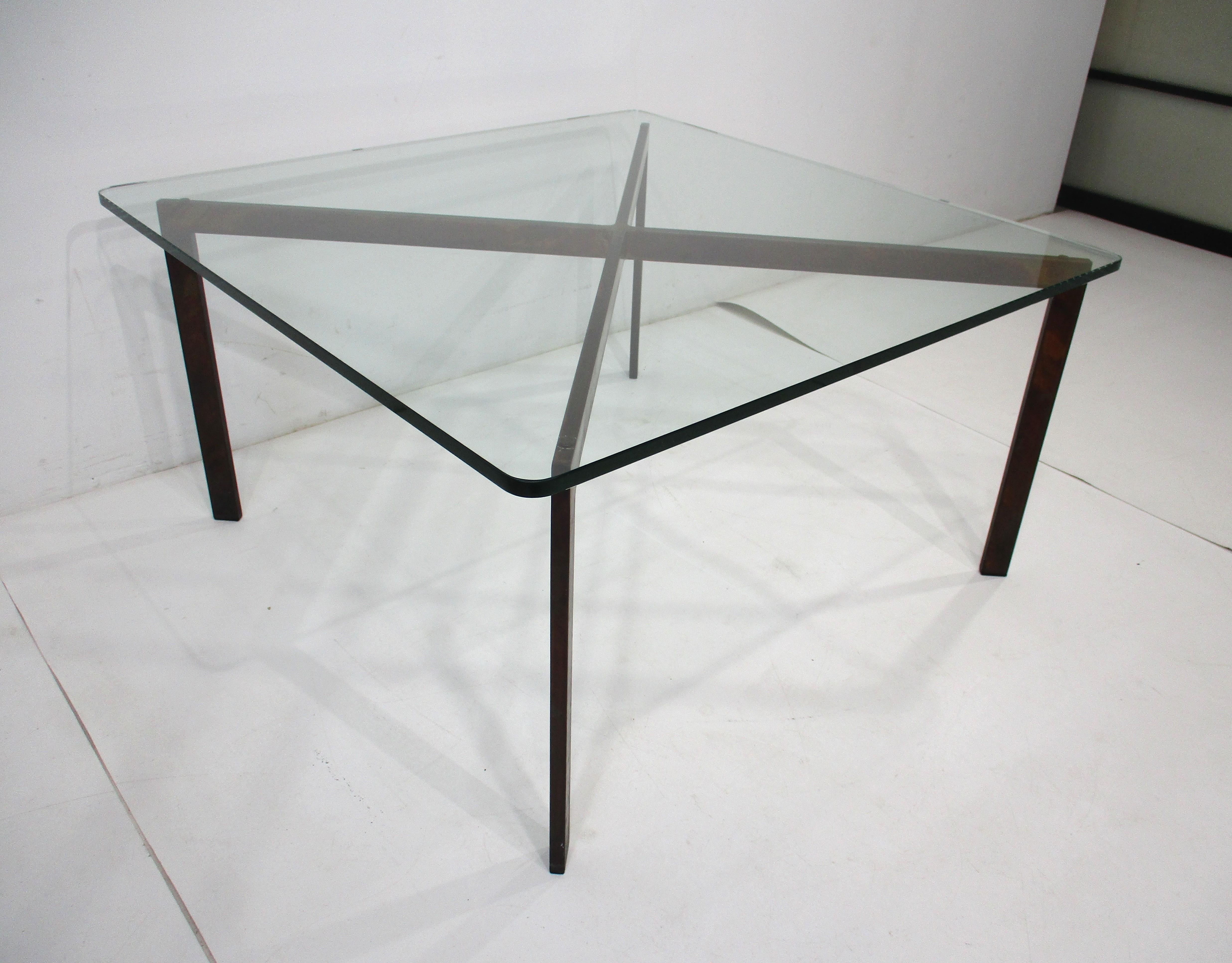 Table basse en métal torché du milieu du siècle avec plateau en verre fabriqué à la manière de la table Barcelona de Knoll. Cette version avec la base tonique donne une nouvelle vie à cette forme emblématique en la ramenant à l'époque des années