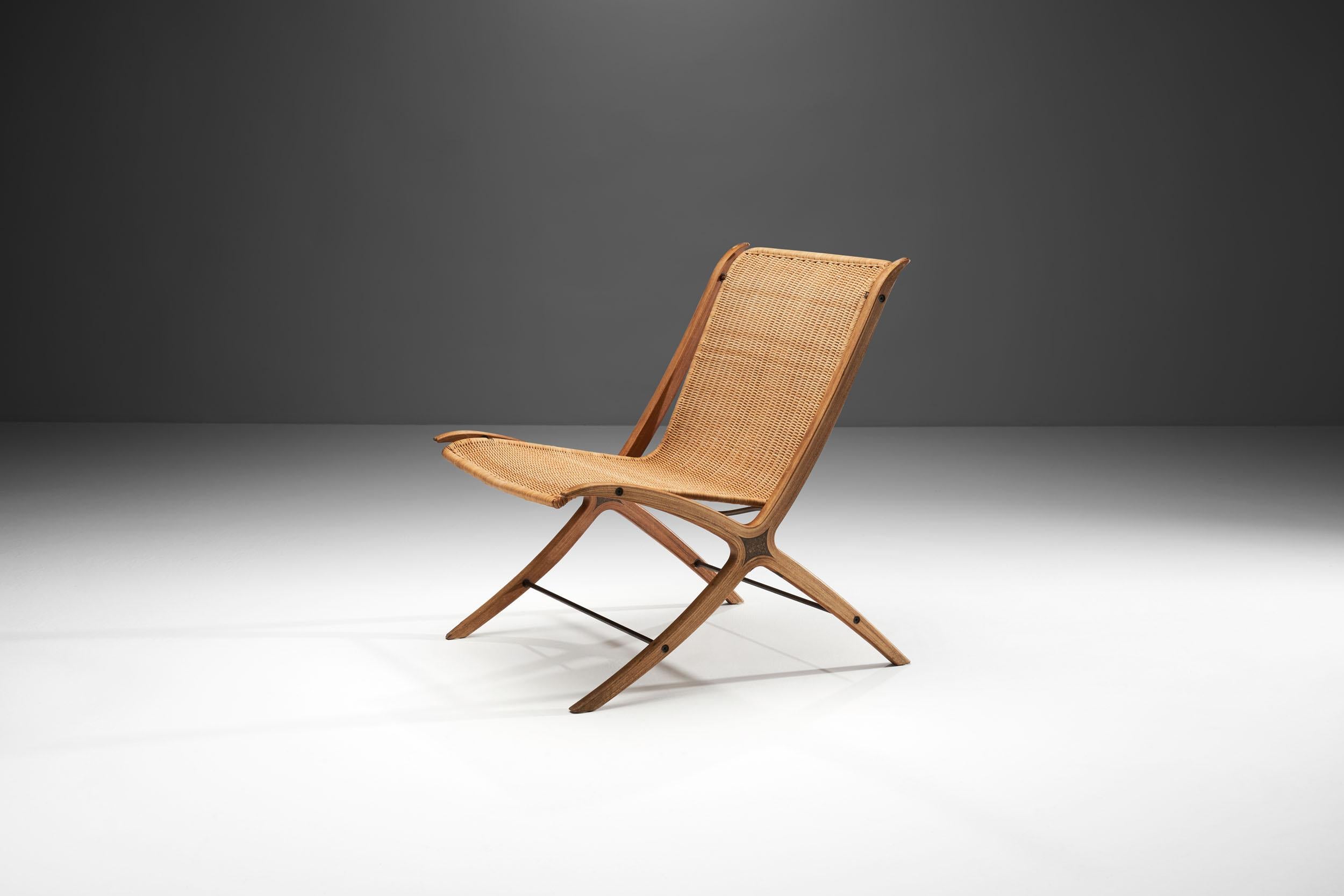 This easy chair is the Danish designer duo’s famous “FH6135” model, commonly referred to as the “X-Chair”. The name derives from the distinctive X-shaped side frames of the chair. This detail contributes to the flowing, unbroken lines of the side