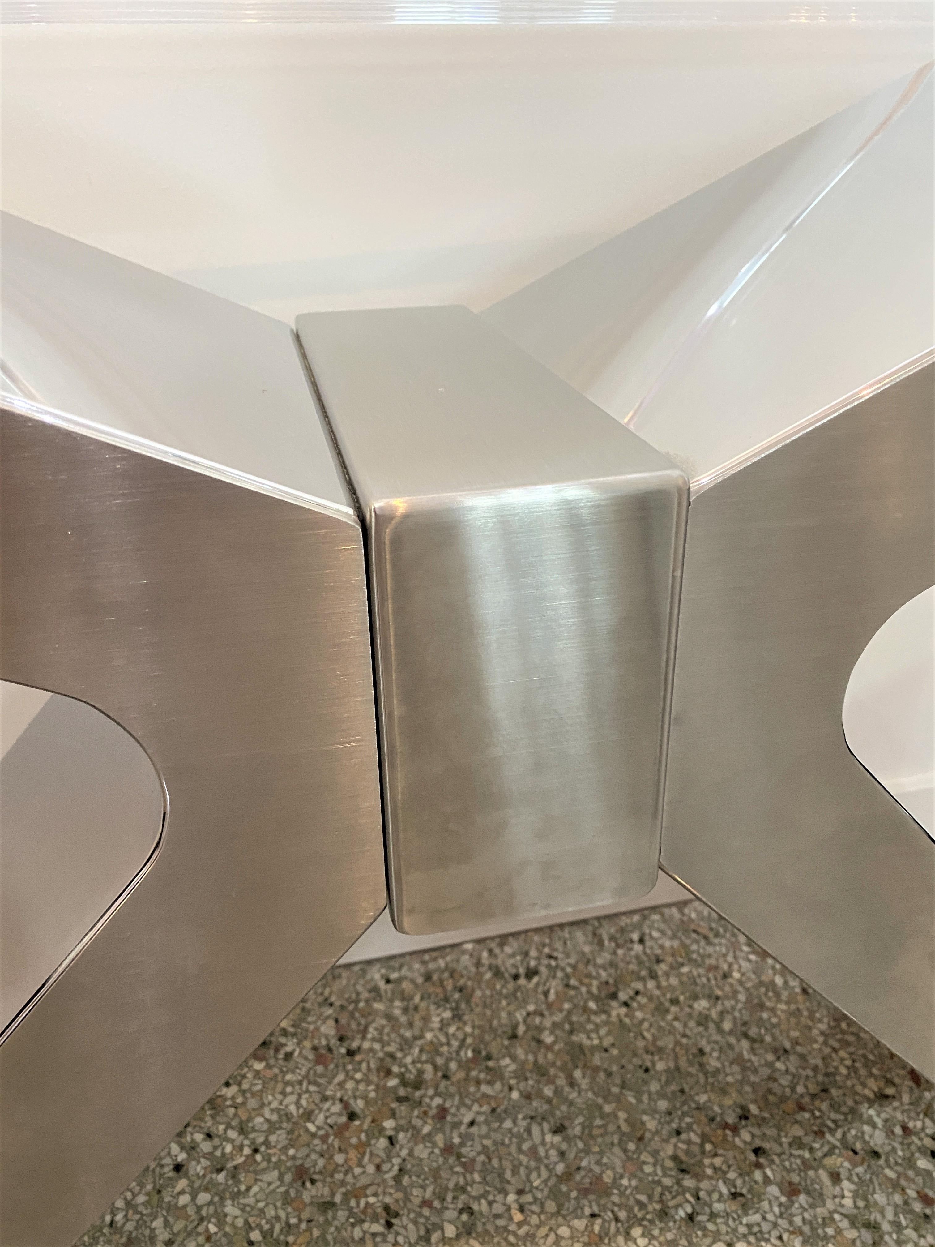 This stylish and bold X-form console table is fabricated in stainless steel and polished Lucite. The front and back of the X-form base are in a satin finish and the sides of the X-form are in a polished finish.