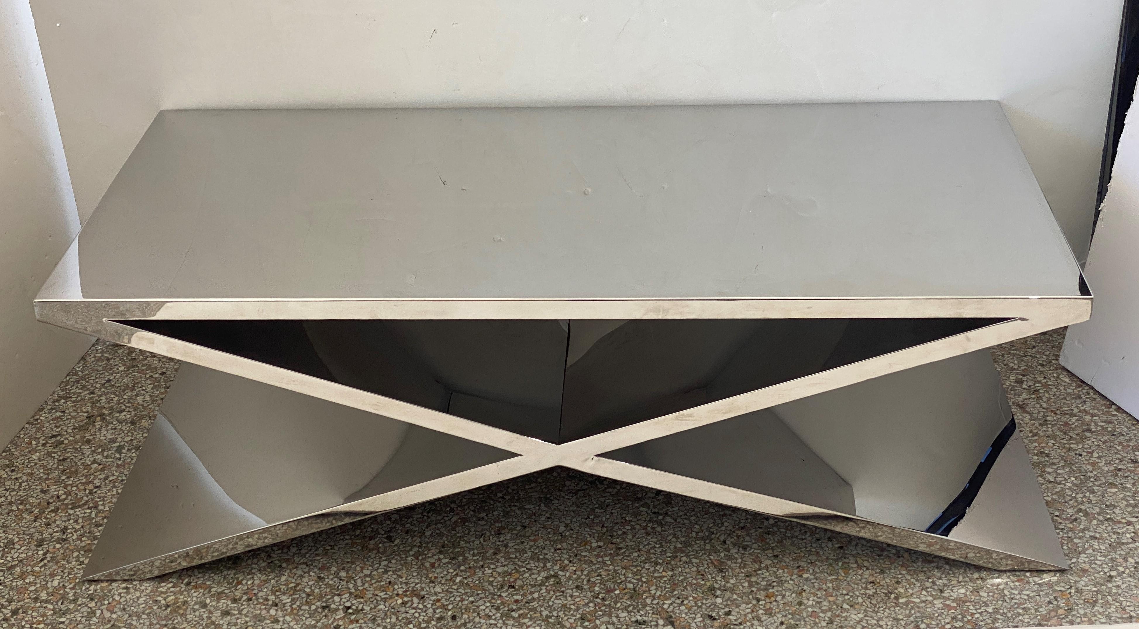 This stylish and substantial X-form polished stainless steel cocktail table was acquired from a Palm Beach yacht and thus it has a substantial weight of 100-200 lbs (guesstimate) to remain in place upon the open sea. 

Note: The scratches on the top