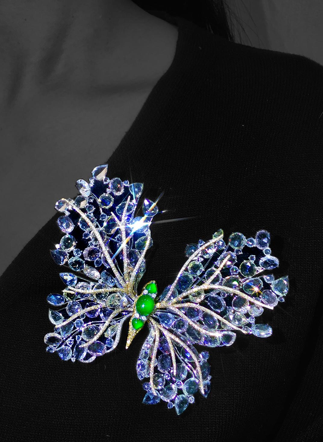 Exquisito broche de mariposa de jade imperial birmano de la antigua mina de cristal, elaborado con titanio y oro de 18 quilates.

Mide 101,6 x 85 x 26,8 mm y presenta 4,11 quilates de diamantes, 97,12 quilates de zafiros blancos y 2,56 quilates de