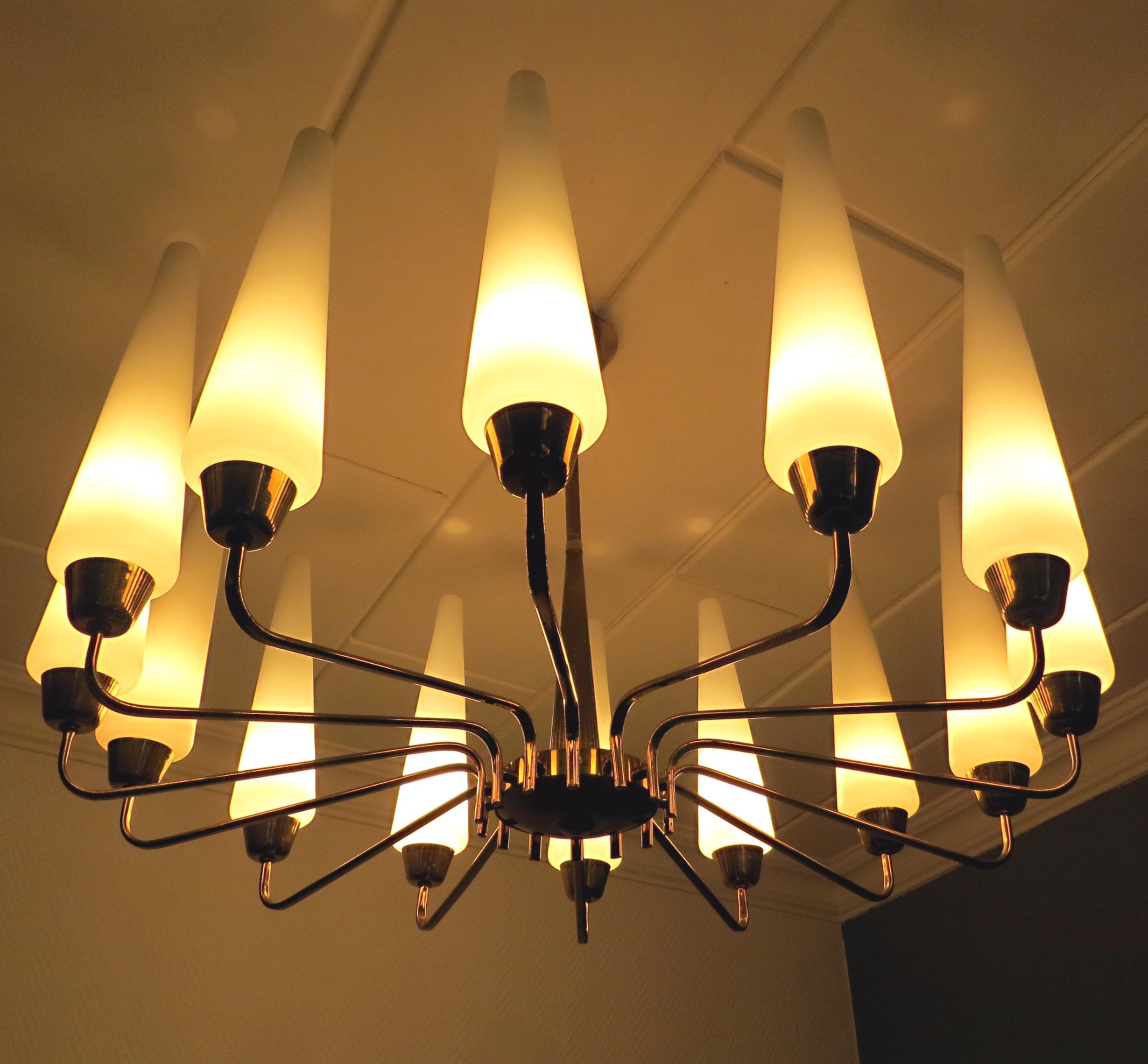 Offriamo qui un esclusivo lampadario Sputnik o Tulipano, moderno e senza tempo, con un diametro di quasi 31,5 pollici, proveniente dalla Francia, negli anni Cinquanta.
La plafoniera vintage ha 14 imbuti in vetro. Il design è in stile Arlus, Stilnovo