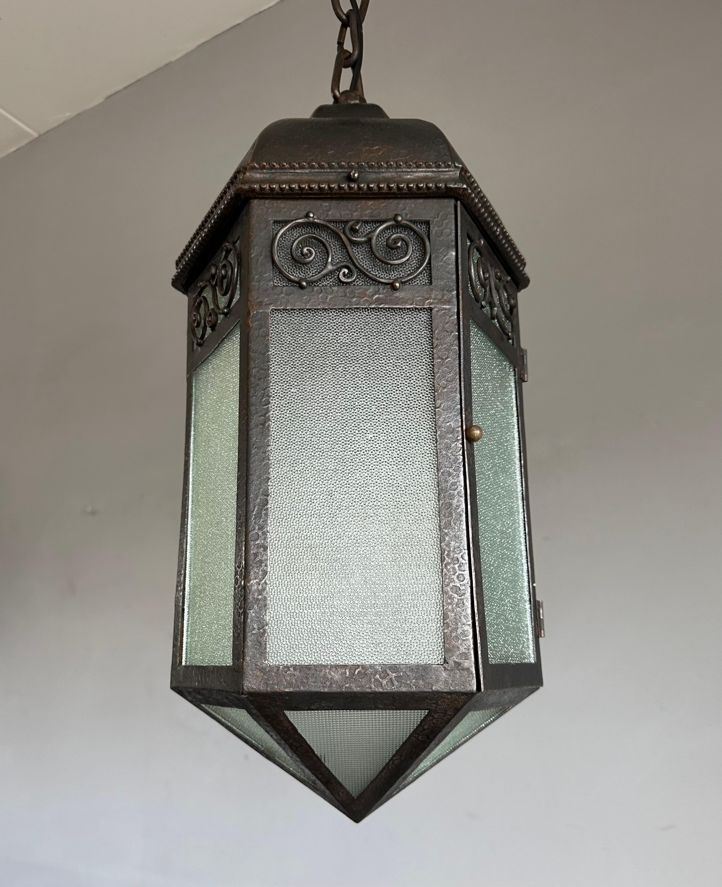 Unique and great looking, antique hall lantern of formidable size.

This unique light fixture of a wonderful design is both finely made and great looking. It is all handcrafted out of wrought iron and cast iron and because of the durability of these