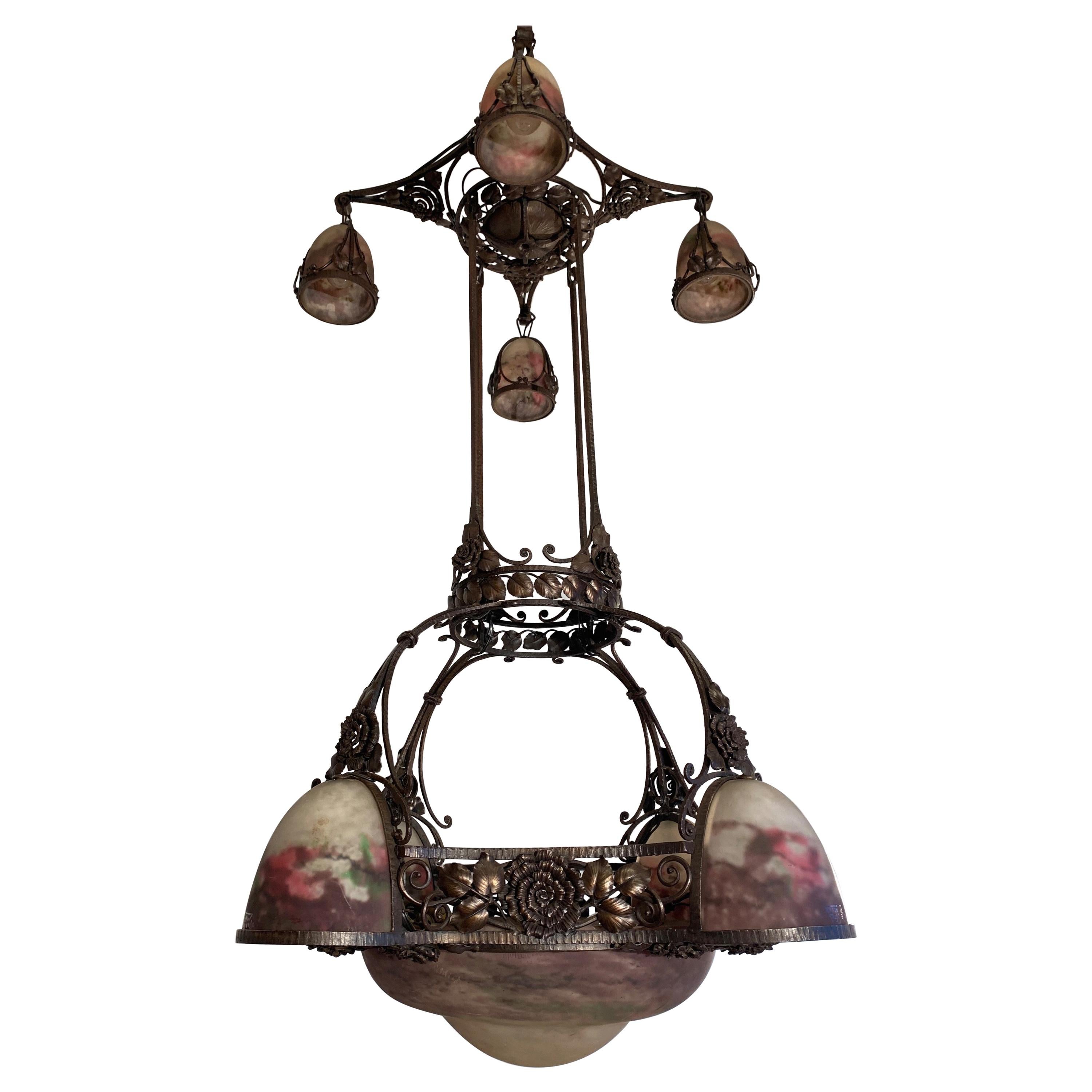 Spectacular and largest hand forged Art Deco pendant light with striking art glass shades.

This monumental and all handcrafted Art Deco two-tier light fixture from the heydays of the French Art Deco era is among the best pieces we ever had the