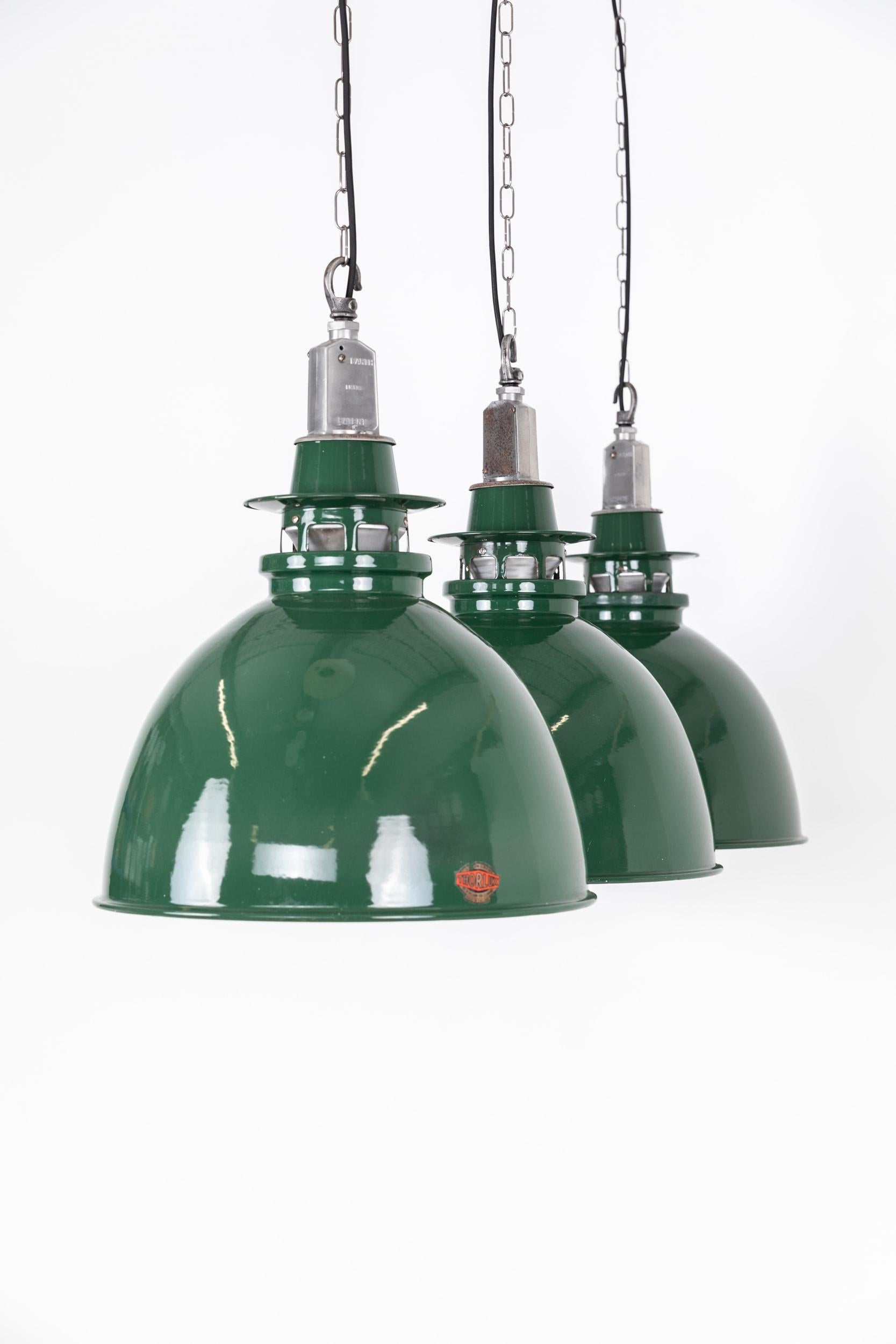 A run of green vitreous enamel pendant lights by renowned lighting manufactures Thorlux. c.1940

Two-part enamel shades, overall in great original condition with only some age related marks and stripped cast galleries. Makers labels present on all