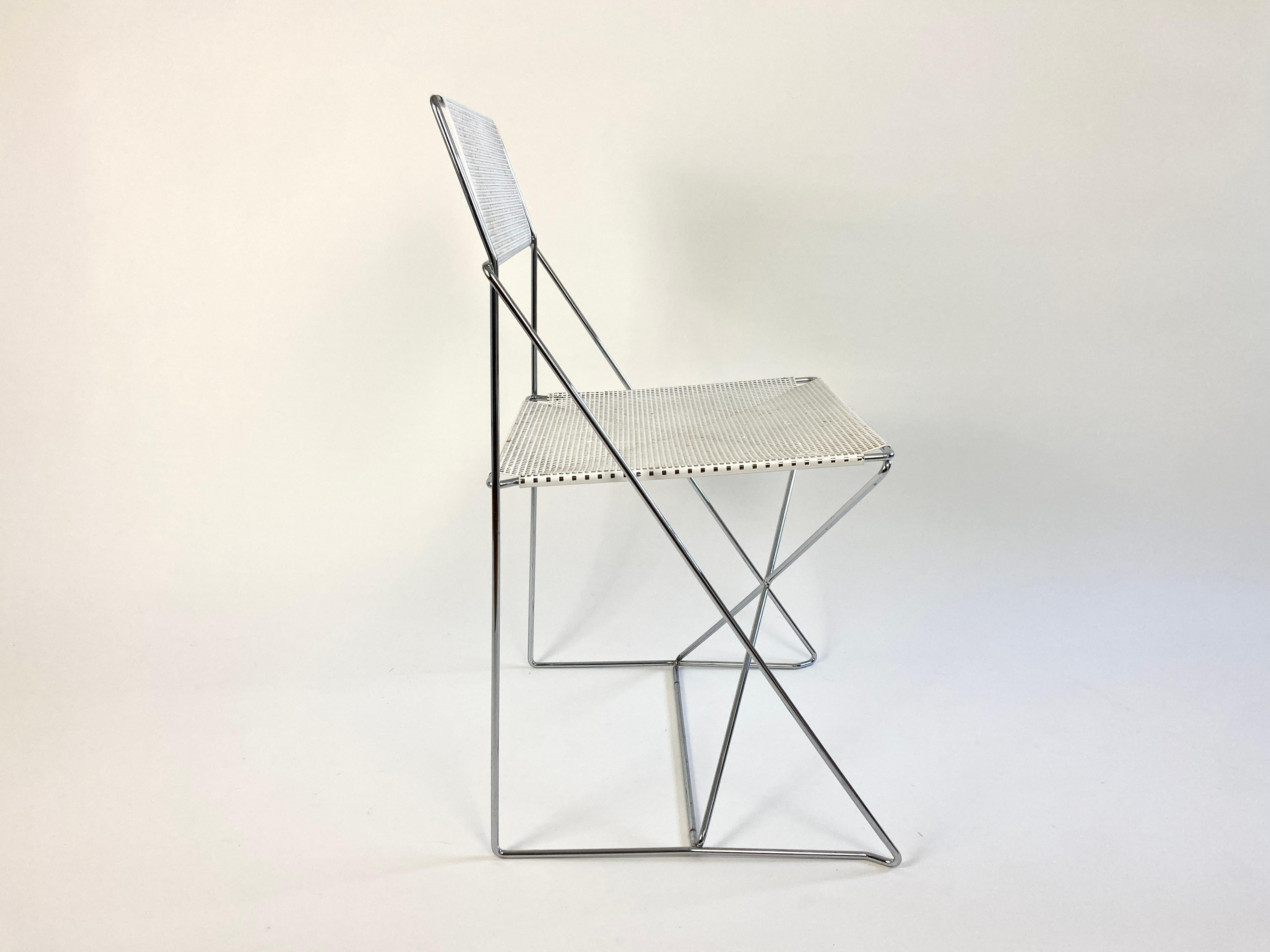 X-line chair designed by architect Niels Jørgen Haugesen in 1977 and manufactured by Hybodan.

Minimalist postmodern design with simple graphic form 

Chrome plated steel frame and perforated powder coated metal sheet seat and backrest. 

No