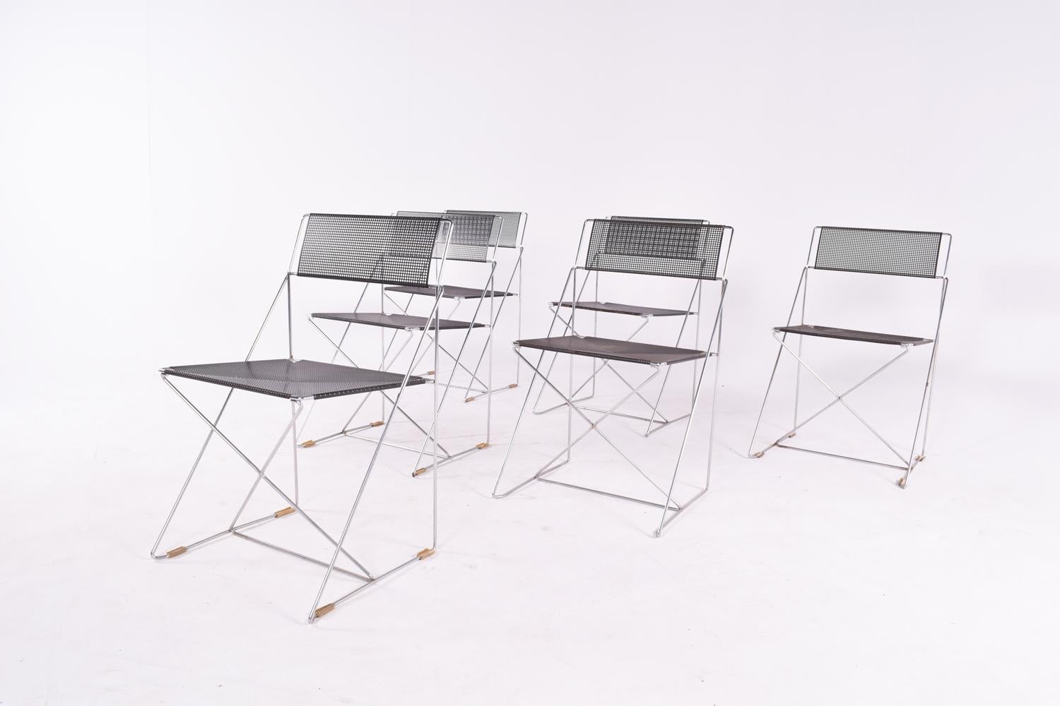 Set of 6 dining chairs in X-line, made of chrome-plated steel rods and black enameled perforated steel backs and seats. Designed by Niels Jorgen Haugesen for Magis. These chairs are stackable. Denmark.