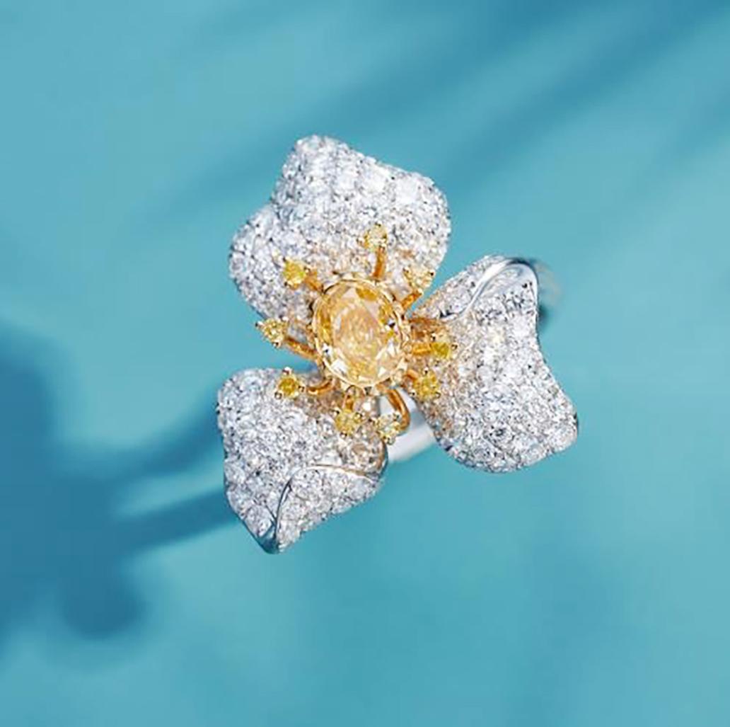 Dieser exquisite Stiefmütterchenring fängt den Geist der Blume ein, der sich durch Widerstandsfähigkeit und edle Anmut auszeichnet. 
Seine Vorderseite ist mit gelben Brillanten besetzt, die die zarten, sich überlappenden Blütenblätter bilden. Diese