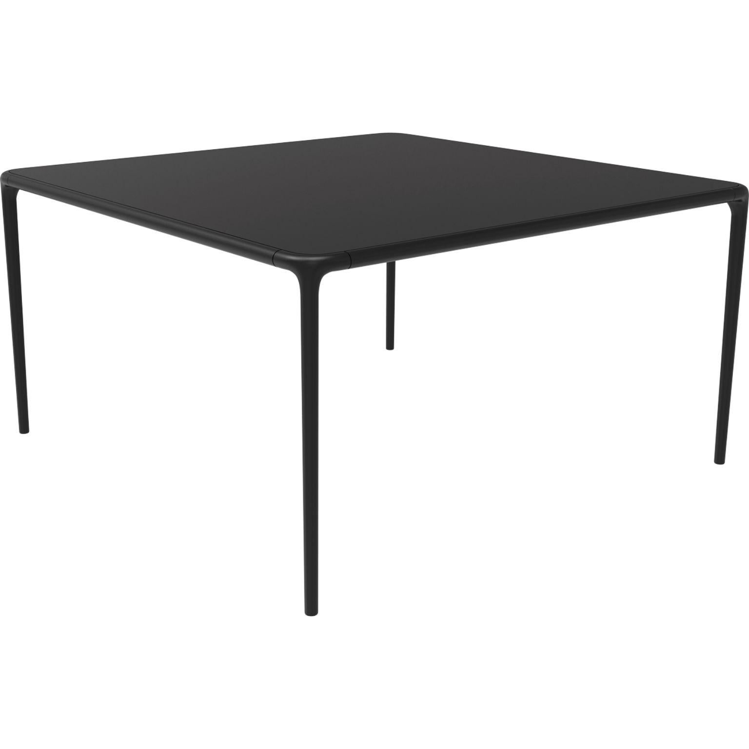 Xaloc black glass top table 140 by MOWEE
Dimensions: D140 x W140 x H74 cm
Material: Aluminum, tinted tempered glass top.
Also available in different aluminum colors and finishes (HPL Black Edge or Neolith). 

Xaloc synthesizes the lines of
