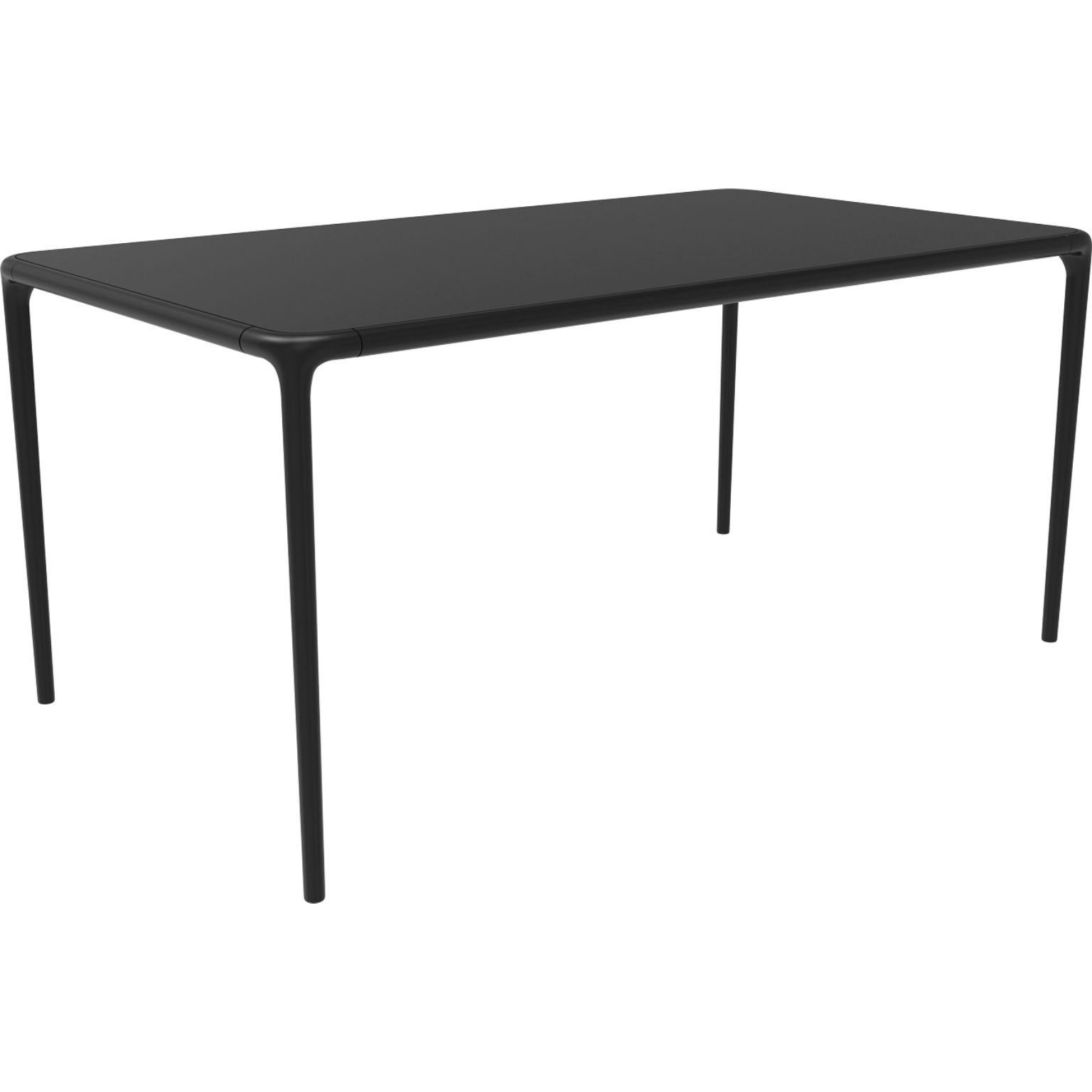 Xaloc black glass top table 160 by Mowee
Dimensions: D 160 x W 90 x H 74 cm
Material: Aluminum, tinted tempered glass top.
Also available in different aluminum colors and finishes (HPL Black Edge or Neolith).

 Xaloc synthesizes the lines of