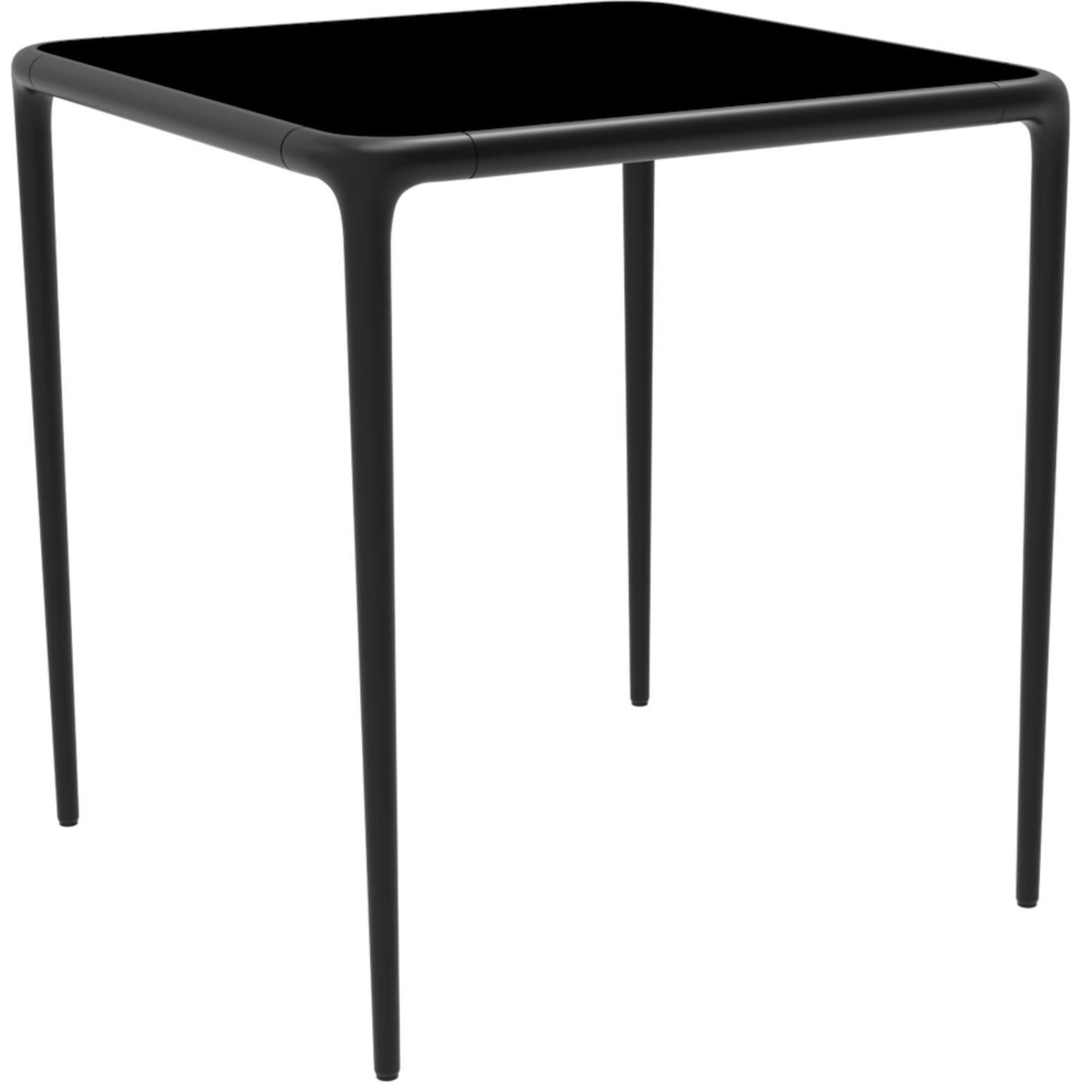 Xaloc black glass top table 70 by MOWEE
Dimensions: D70 x W70 x H74 cm
Material: Aluminum, tinted tempered glass top.
Also available in different aluminum colors and finishes (HPL Black Edge or Neolith). 

Xaloc synthesizes the lines of