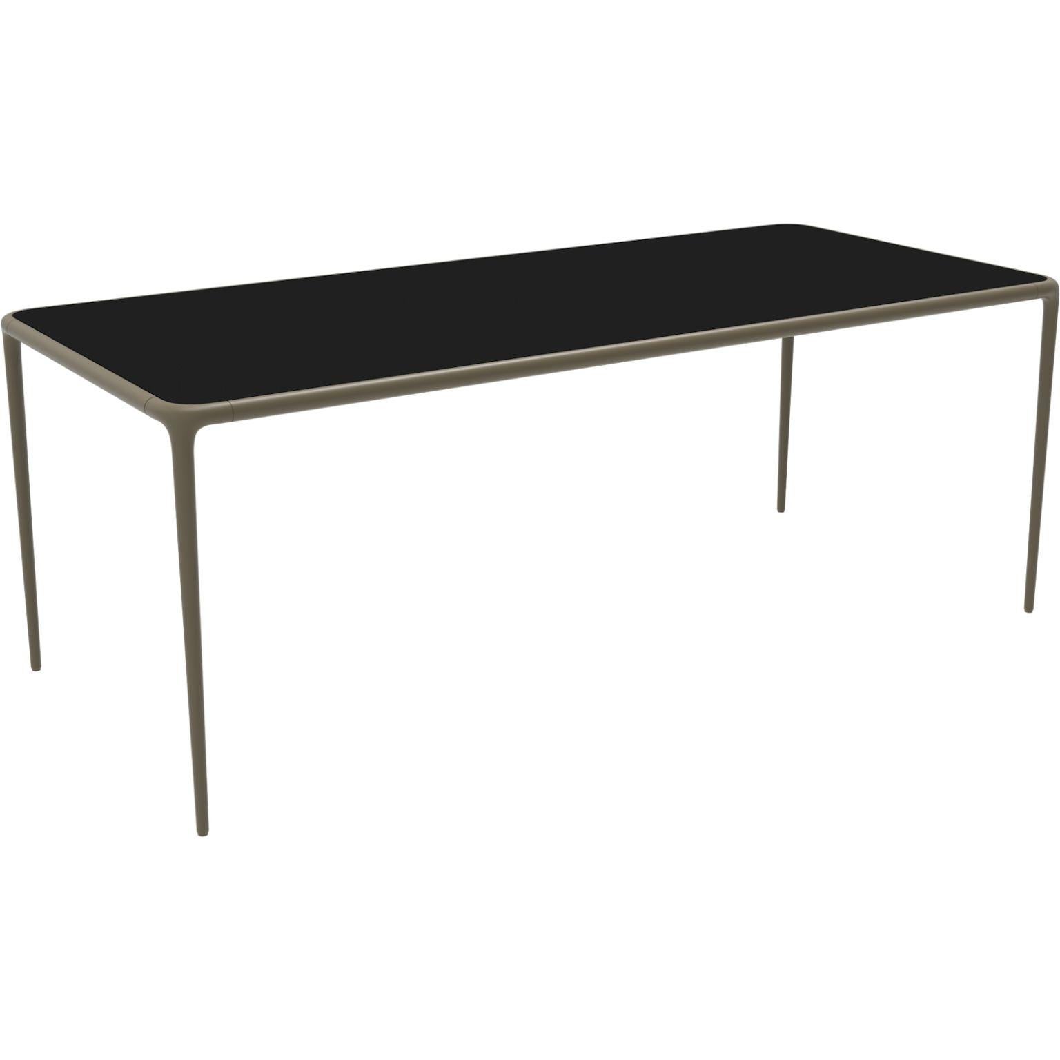 Xaloc bronze glass top 200 table by Mowee
Dimensions: D 200 x W 90 x H 74 cm
Material: Aluminium, tinted tempered glass top.
Also available in different aluminum colors and finishes (HPL Black Edge or Neolith).

Xaloc synthesizes the lines of