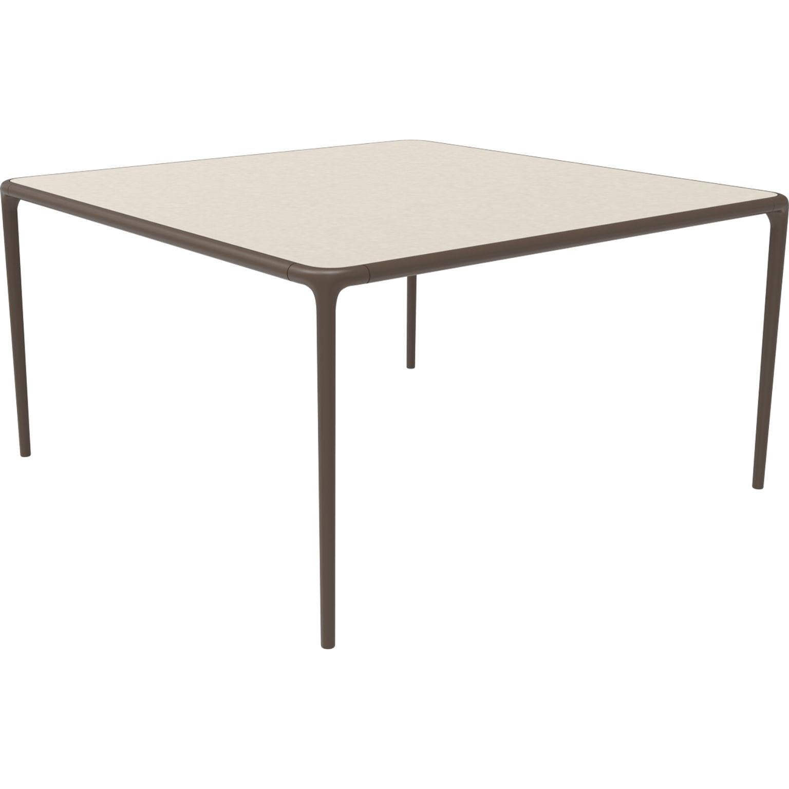 Xaloc bronze glasstop table 140 by Mowee
Dimensions: D 140 x W 140 x H 74 cm
Material: Aluminum, tinted tempered glass top.
Also available in different aluminum colors and finishes (HPL Black Edge or Neolith).

Xaloc synthesizes the lines of