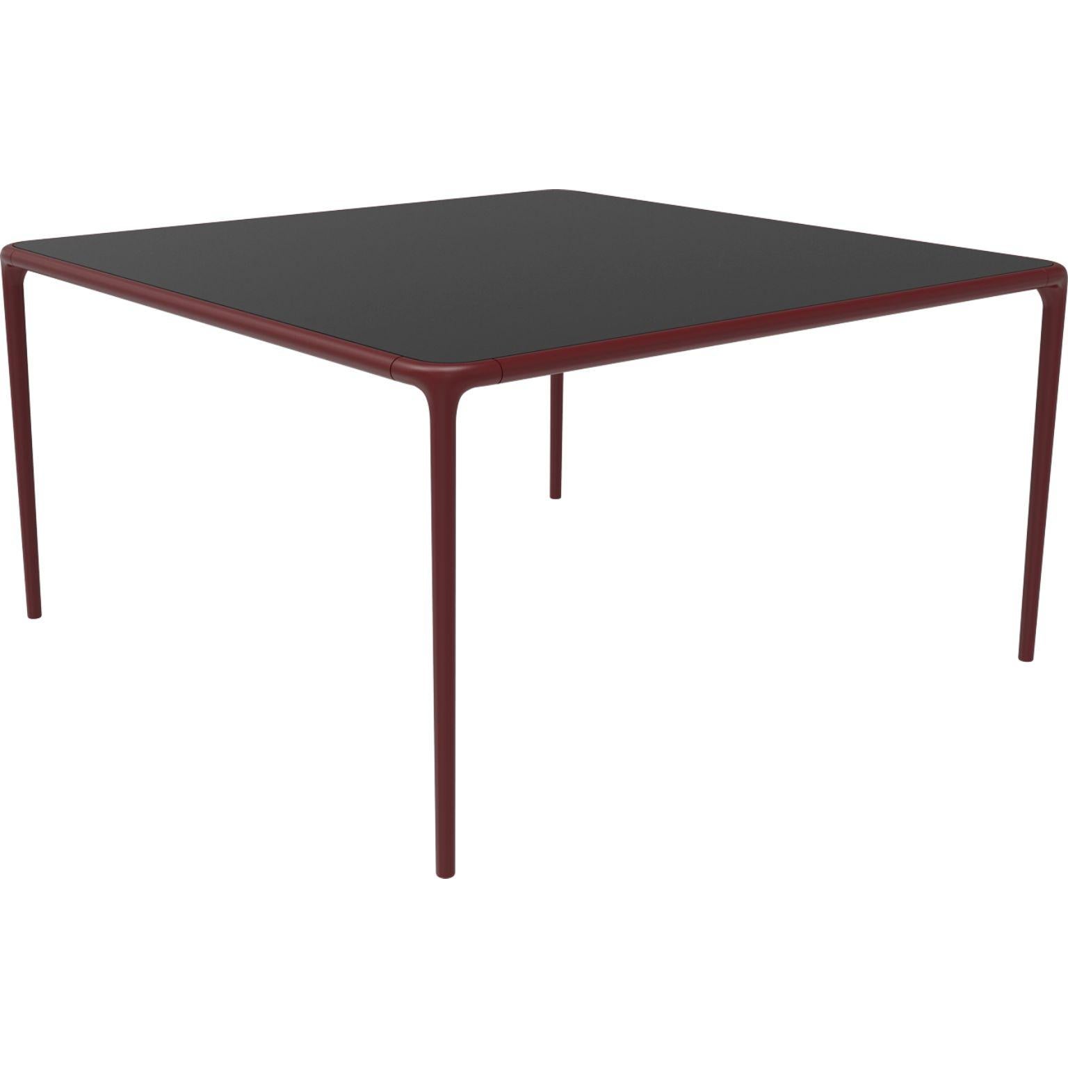 Xaloc burgundy glass top table 140 by MOWEE
Dimensions: D140 x W140 x H74 cm
Material: Aluminum, tinted tempered glass top.
Also available in different aluminum colors and finishes (HPL Black Edge or Neolith). 

Xaloc synthesizes the lines of