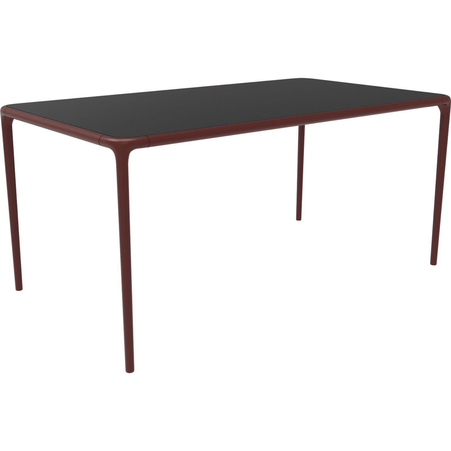 Xaloc burgundy glass top table 160 by MOWEE
Dimensions: D160 x W90 x H74 cm
Material: Aluminum, tinted tempered glass top.
Also available in different aluminum colors and finishes (HPL Black Edge or Neolith). 

 Xaloc synthesizes the lines of