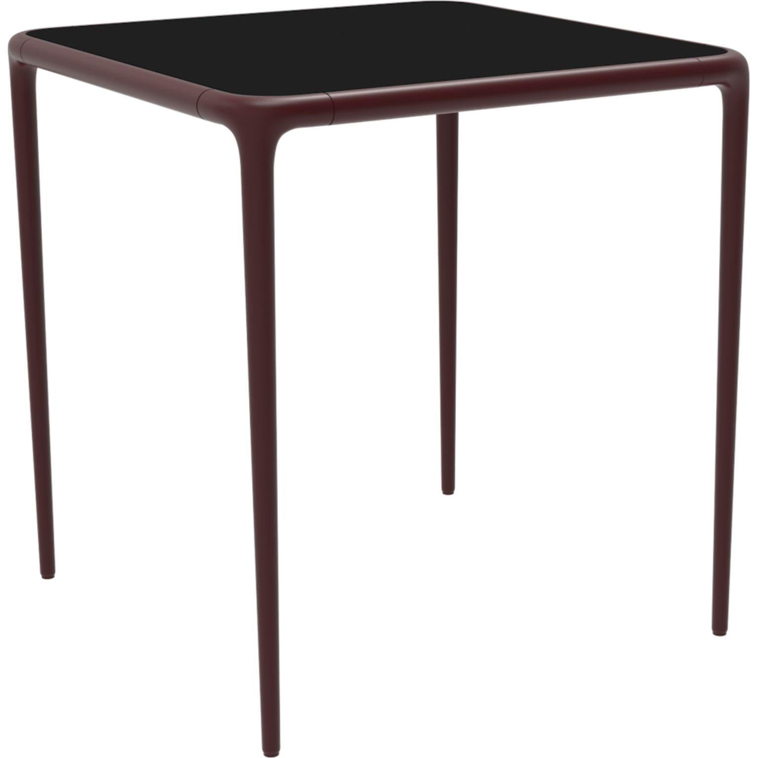 Xaloc Burgundy glass top table 70 by MOWEE
Dimensions: D70 x W70 x H74 cm
Material: Aluminum, tinted tempered glass top.
Also available in different aluminum colors and finishes (HPL Black Edge or Neolith). 

Xaloc synthesizes the lines of