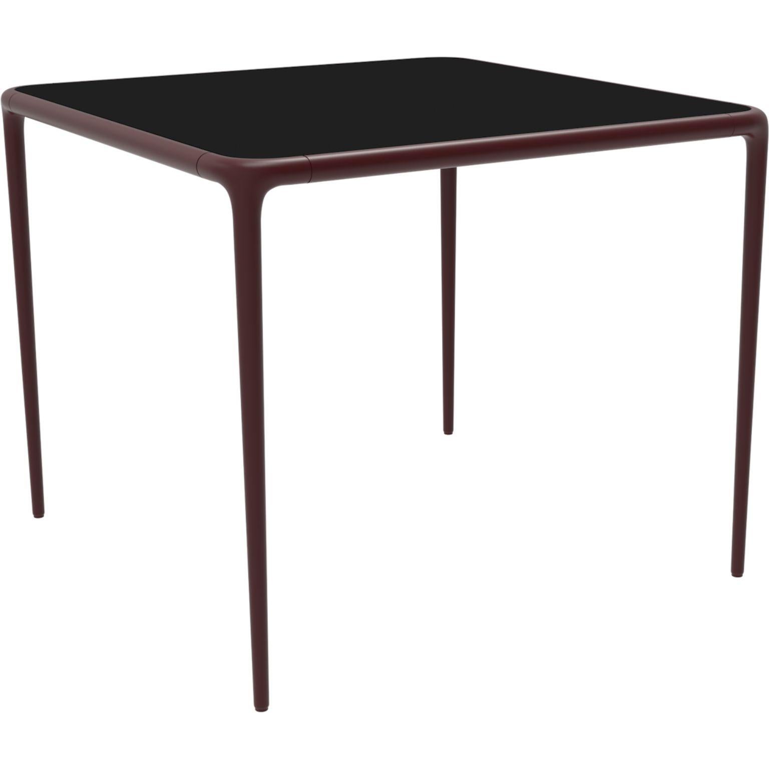 Xaloc Burgundy Glass Top Table 90 by Mowee.
Dimensions: D90 x W90 x H74 cm.
Material: Aluminum, tinted tempered glass top.
Also available in different aluminum colors and finishes (HPL Black Edge or Neolith).

 Xaloc synthesizes the lines of