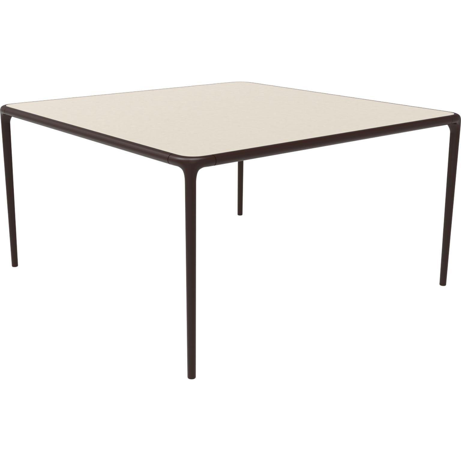 Xaloc chocolate glass top table 140 by Mowee.
Dimensions: D140 x W140 x H74 cm.
Material: Aluminum, tinted tempered glass top.
Also available in different aluminum colors and finishes (HPL Black Edge or Neolith).

Xaloc synthesizes the lines of
