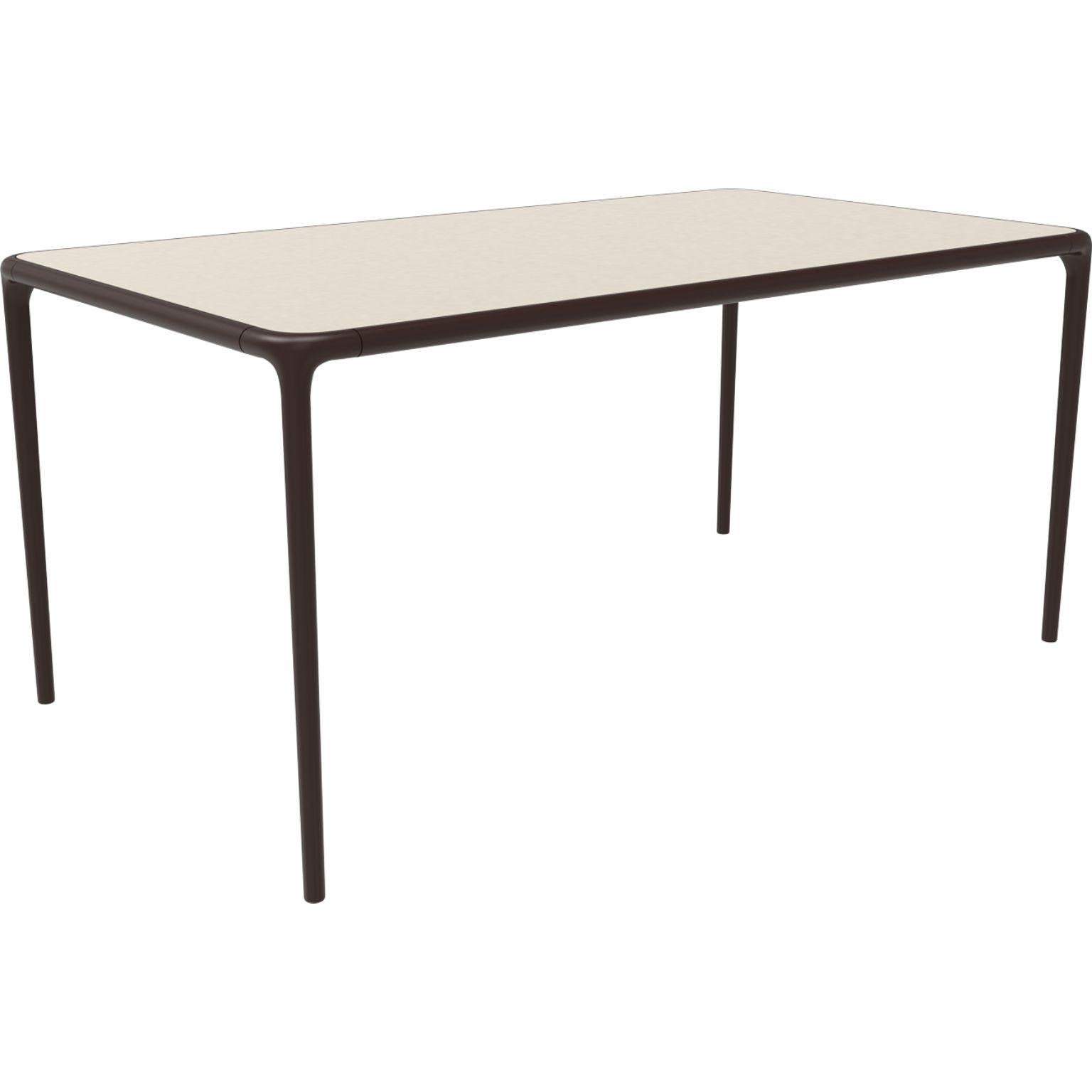Xaloc chocolate glass top table 160 by MOWEE
Dimensions: D160 x W90 x H74 cm
Material: Aluminum, tinted tempered glass top.
Also available in different aluminum colors and finishes (HPL Black Edge or Neolith). 

 Xaloc synthesizes the lines of