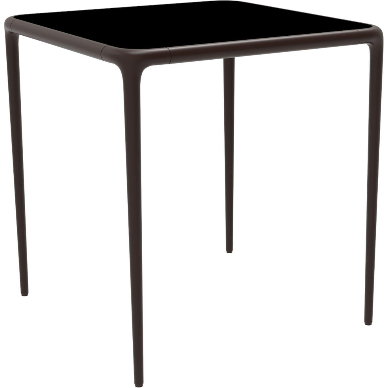 Xaloc chocolate glass top table 70 by Mowee
Dimensions: D 70 x W 70 x H 74 cm
Material: Aluminum, tinted tempered glass top.
Also available in different aluminum colors and finishes (HPL Black Edge or Neolith)

Xaloc synthesizes the lines of