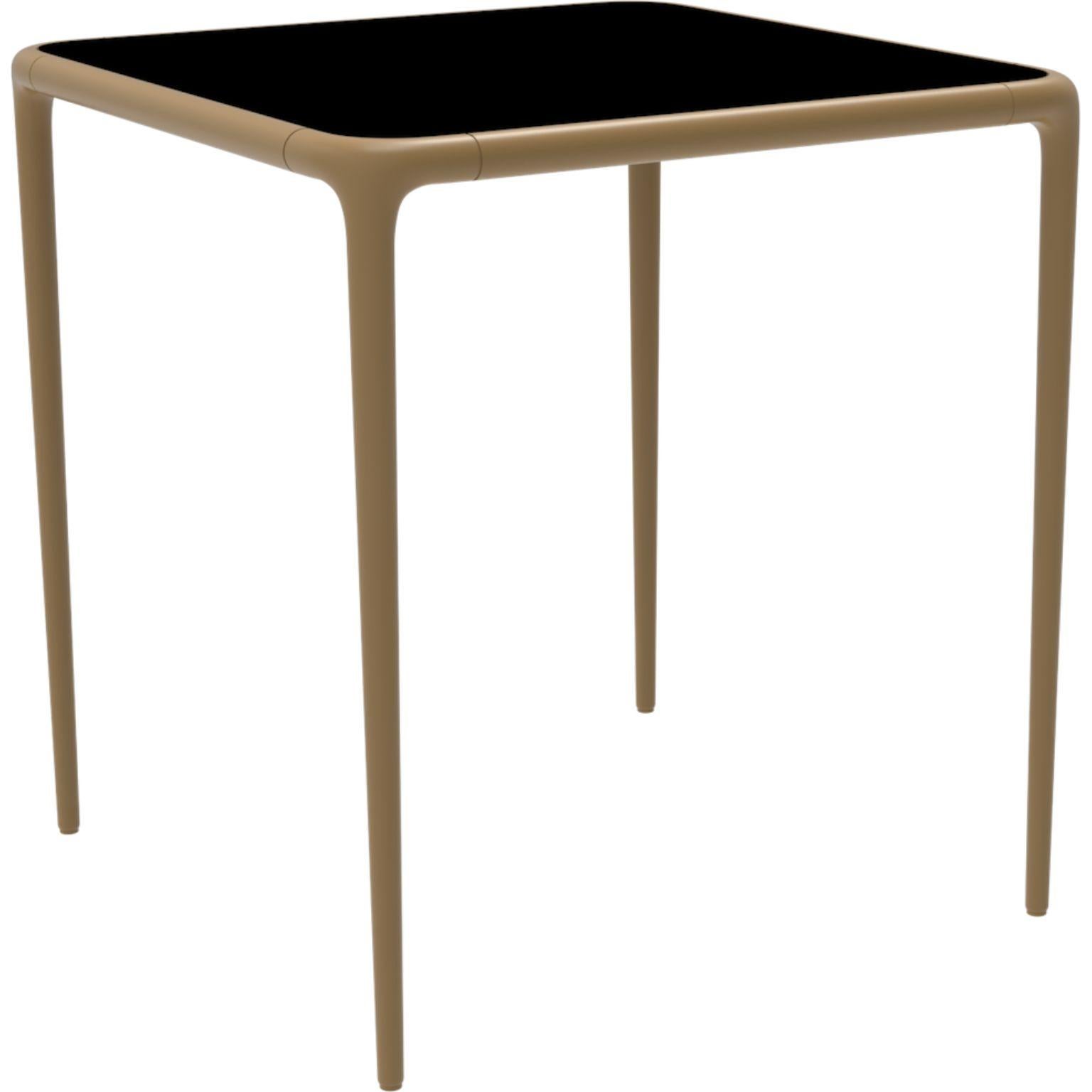 Xaloc Gold glass top table 70 by MOWEE
Dimensions: D70 x W70 x H74 cm
Material: Aluminum, tinted tempered glass top.
Also available in different aluminum colors and finishes (HPL Black Edge or Neolith). 

Xaloc synthesizes the lines of interior