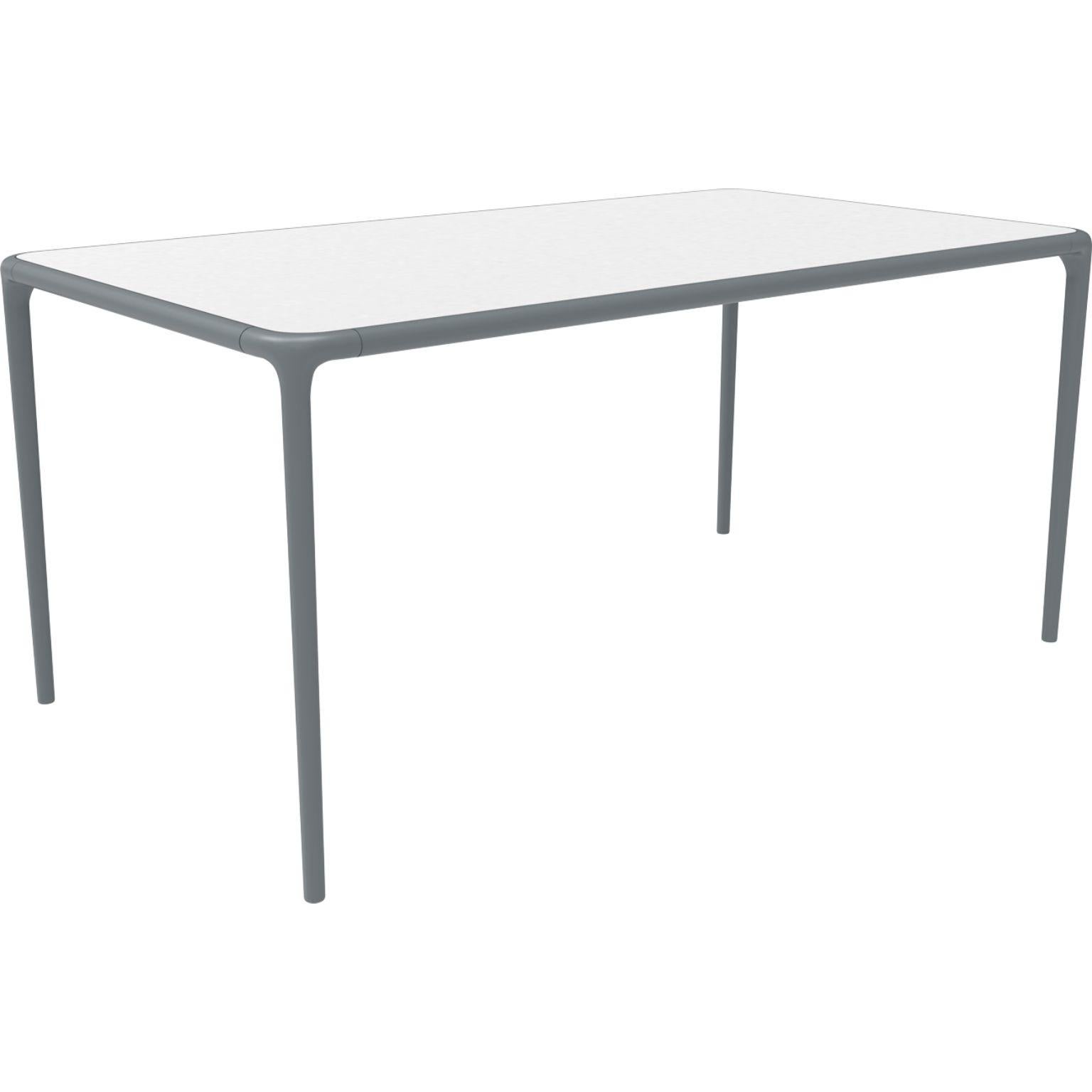 Xaloc grey glass top table 160 by Mowee.
Dimensions: D160 x W90 x H74 cm.
Material: Aluminum, tinted tempered glass top.
Also available in different aluminum colors and finishes (HPL Black Edge or Neolith). 

 Xaloc synthesizes the lines of