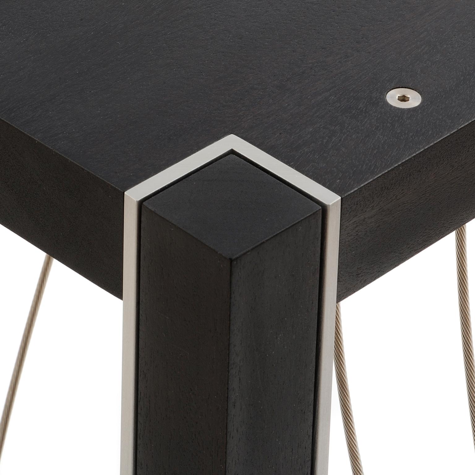 La table Xenon a un plateau carré de 12 pouces et mesure 36 pouces de haut. Ce piédestal présente des câbles en acier inoxydable tordus en une série de courbes agréables. Il a une présence sculpturale pour accentuer de manière unique votre pièce. La