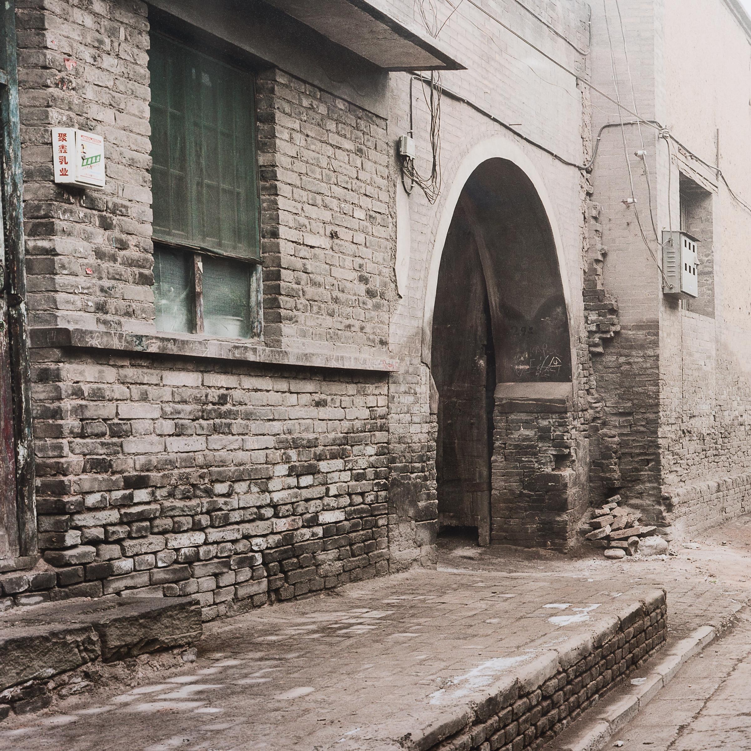 This evocative photograph is part of a series created by artist Sze Tsung Nicolas Leong that explore China’s complicated relationship with its ancient past and anticipated future. In this 2004 photograph, 100-year-old buildings line a vacant street