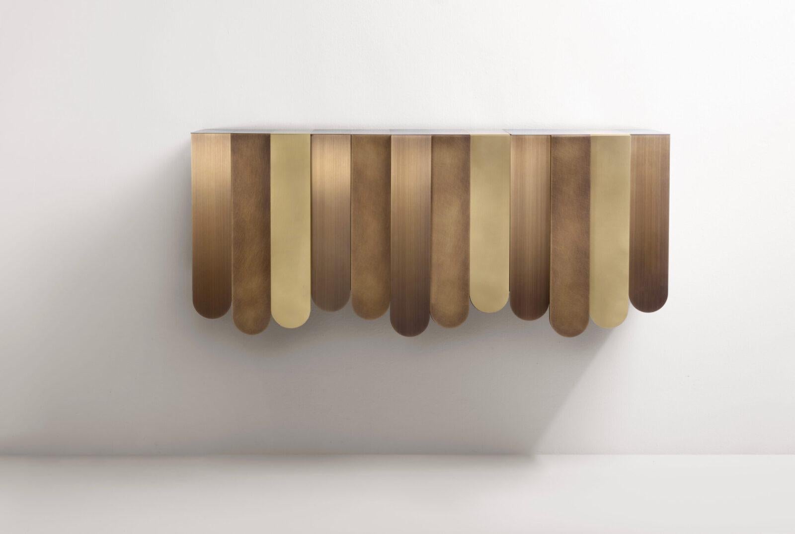 Xilo Console by De Castelli
Dimensions: W 150 x D 42 x H 65 cm
Materials: MIX Brass

The Xilo console is a sculptural volume punctuated by different bands of thick metal sheet folded over the top so that they cover the front and create a sort of