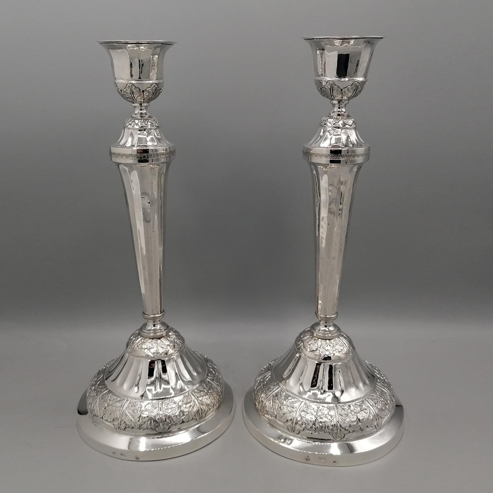 Paire de chandeliers italiens en argent 800 de la première moitié du XIXe siècle, de style Empire.
La base ronde est caractérisée par l'important gaufrage de feuilles d'acanthe sur la partie inférieure. Le même petit motif est répété sur la partie