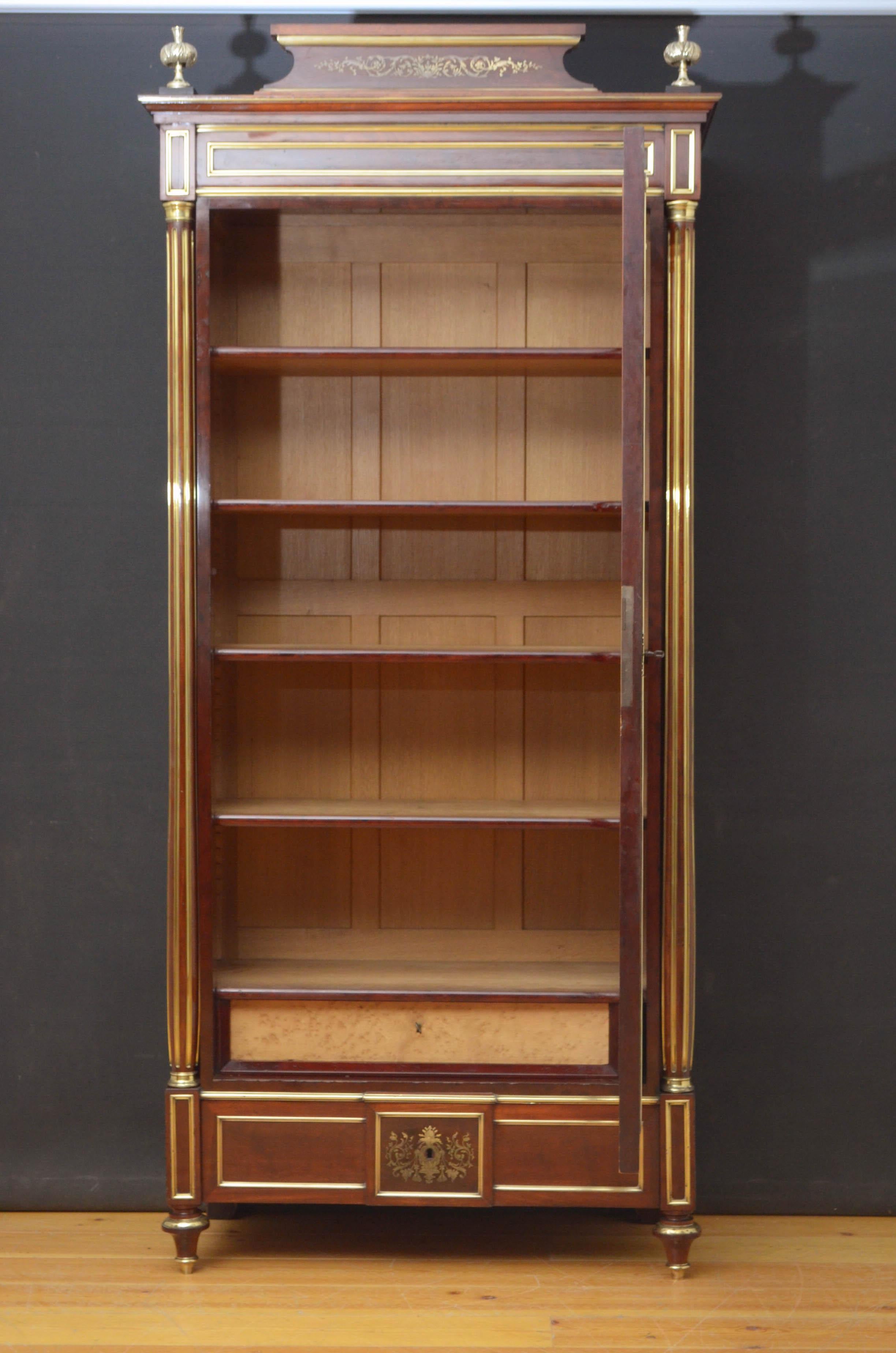 Sn4807 fantastic 19th century brass inlaid bookcase in mahogany, having brass inlaid cornice flanked by brass finials above beveled edge glazed doors fitted with original working lock and a key and enclosing 4 height adjustable shelves and a drawer,