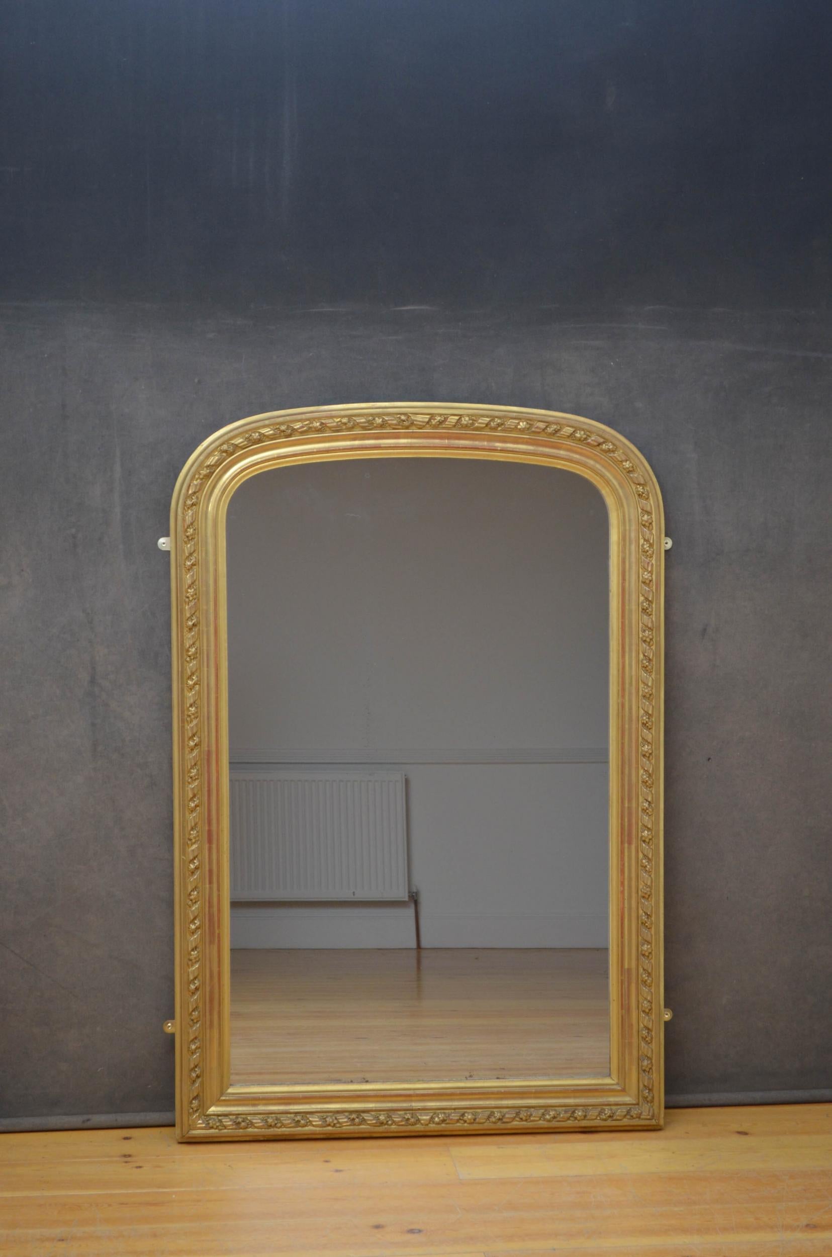 Sn4980, elegant French gilded overmantel mirror, having original mirror plate with some foxing in moulded and floral carved giltwood frame. This antique wall mirror retains its original glass, original gilt and original backboards, all in wonderful