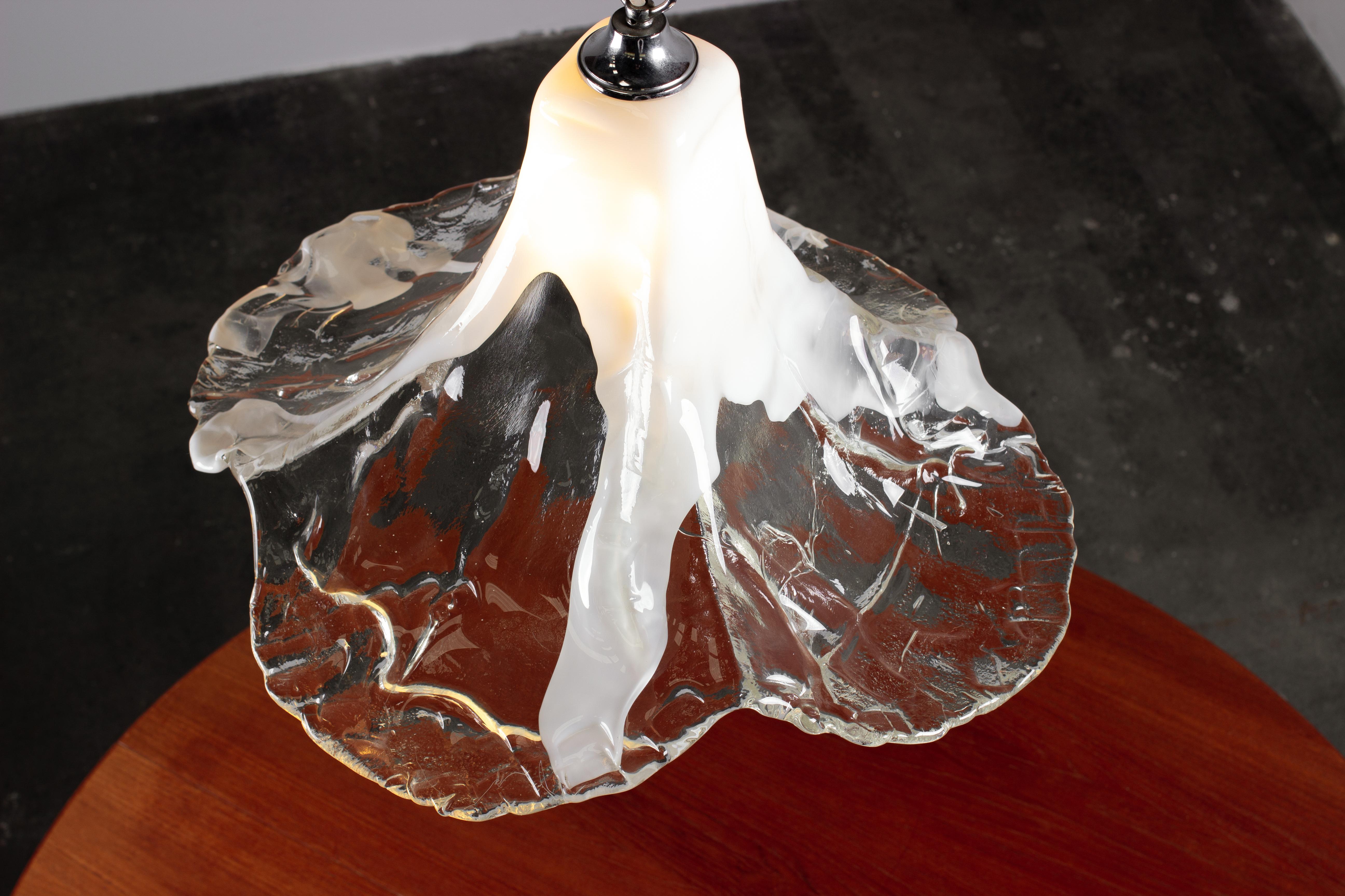 Design by Carlo Nason for Kalmar Franken lighting Austria, handmade by renowned Murano glassworks, Mazzega in Italy.

Mid-Century Modern floral pendant light. Single piece of very thick Murano glass shaped into a bellflower with slender neck at