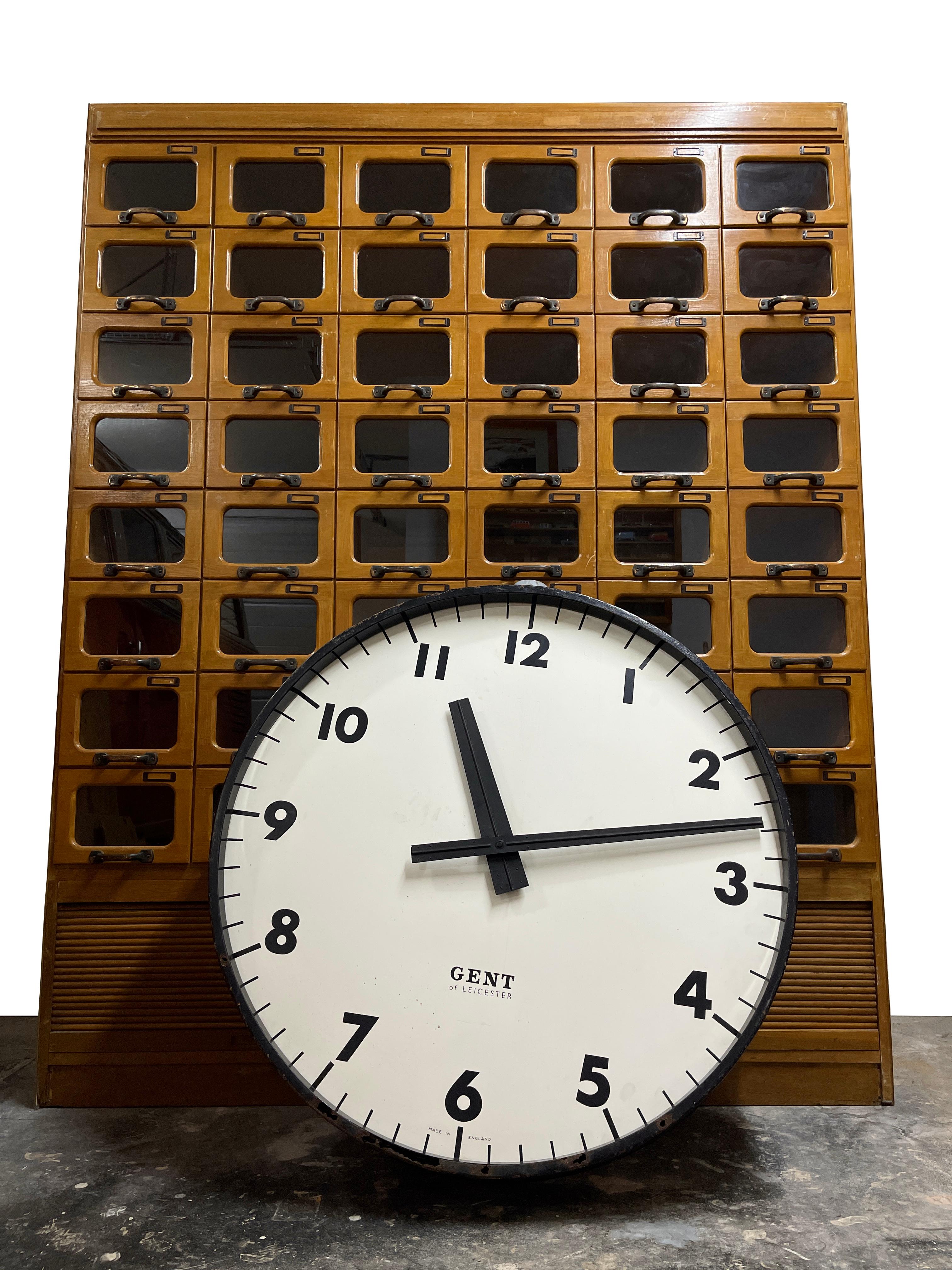 - Une horloge de gare Gents' of Leicester incroyablement rare, d'une proportion énorme, anglaise vers 1940. 
- Un boîtier extérieur noir très lourd et solide avec une plaque arrière d'origine comportant trois pattes pour la fixation au mur.
-
