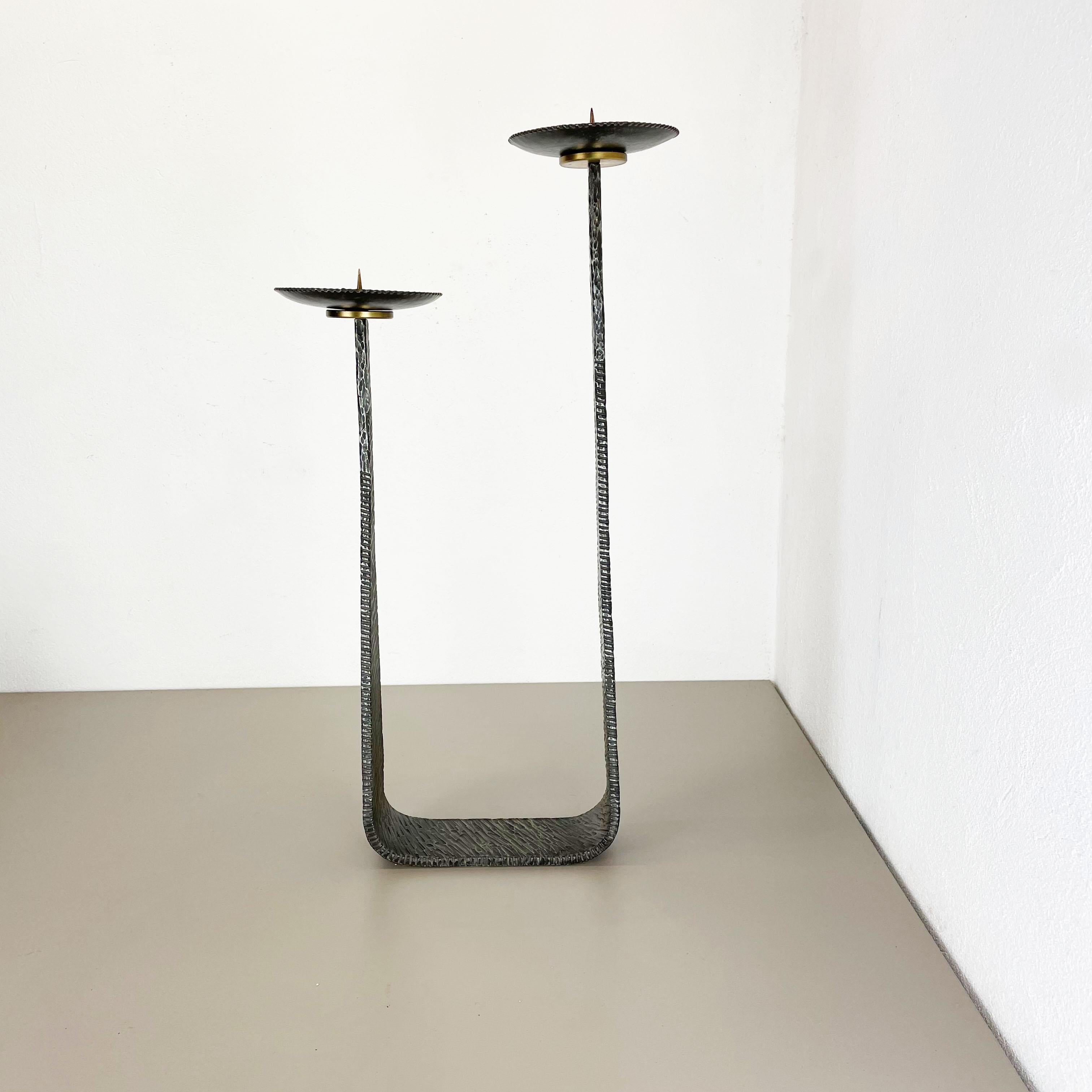 Article: Brutalist floor candleholder

Origin: Germany

Material: Solid metal candleholder

Decade: 1970s

Description: This original vintage candleholder, was produced in the 1970s in germany. it is made of solid heavy metal, and has a