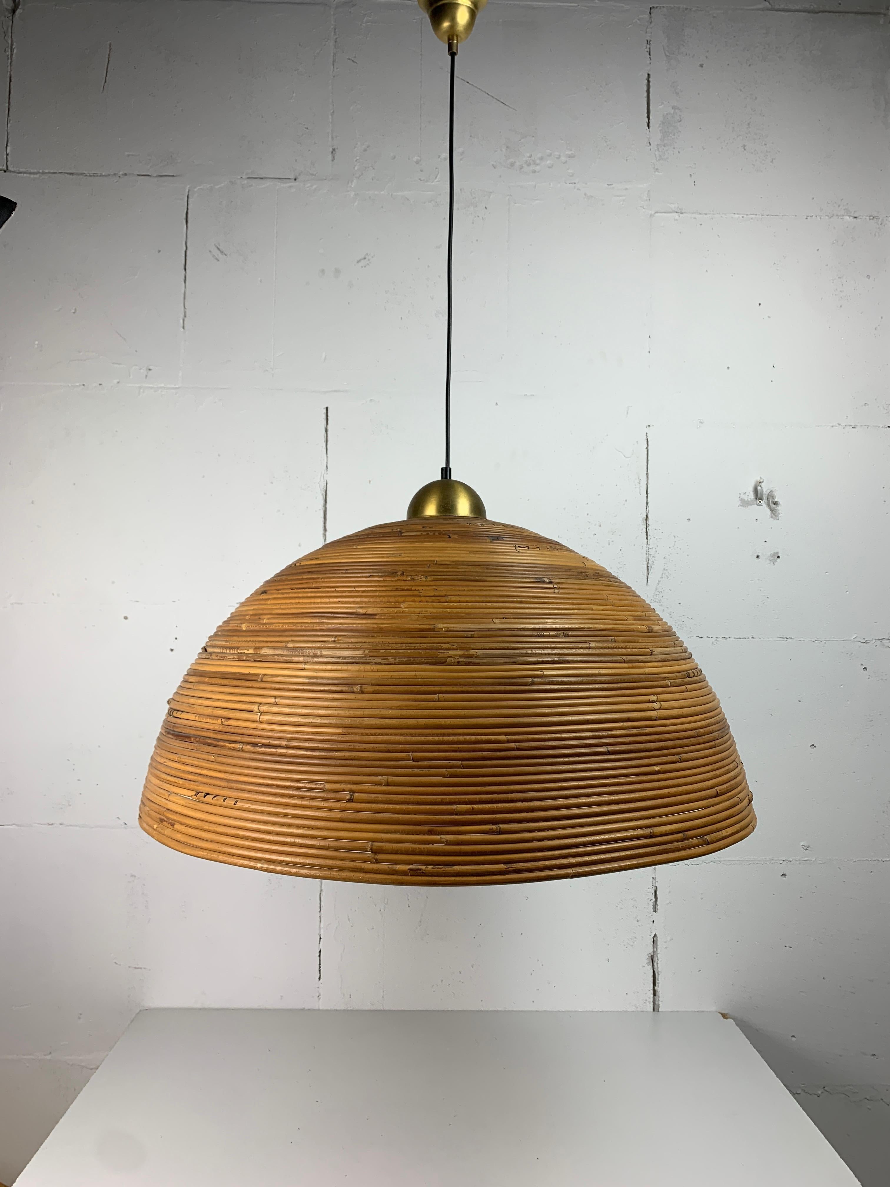 A wonderful and exceptional rare extra large brown pencil or split reed rattan wicker bamboo pendant lamp with brass, Italy. The rattan is still in great condition with no flaws to mention. This lamp is fitted for a general E27 lightbulb. The