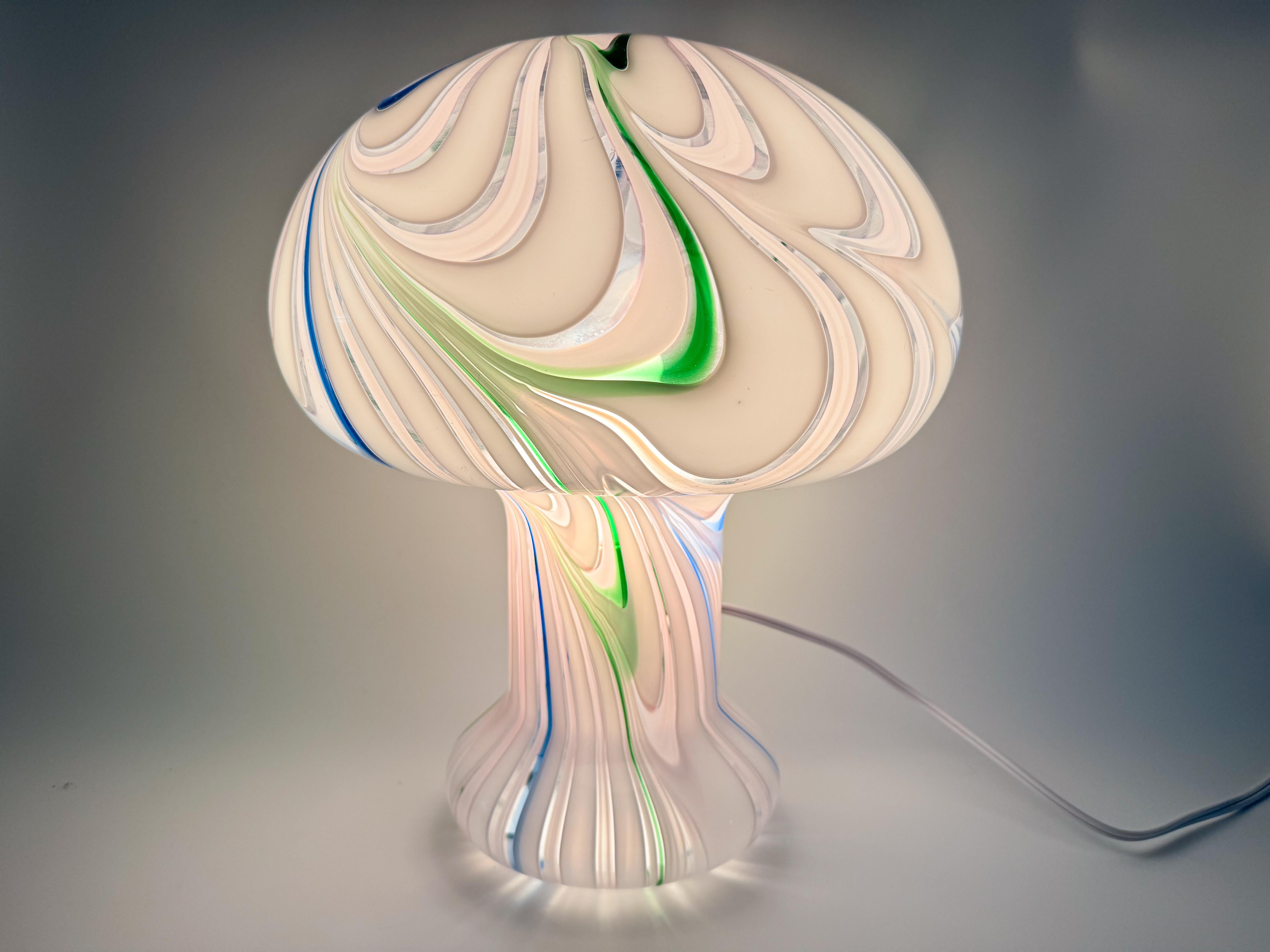 This rare XL Murano glass lamp, crafted in the 1970s by the esteemed, now-closed Ferro e Lazzarini, is a striking example of Italian glass artistry. The lamp features a beautiful swirl pattern in green, blue, white, and pink, meticulously hand-blown