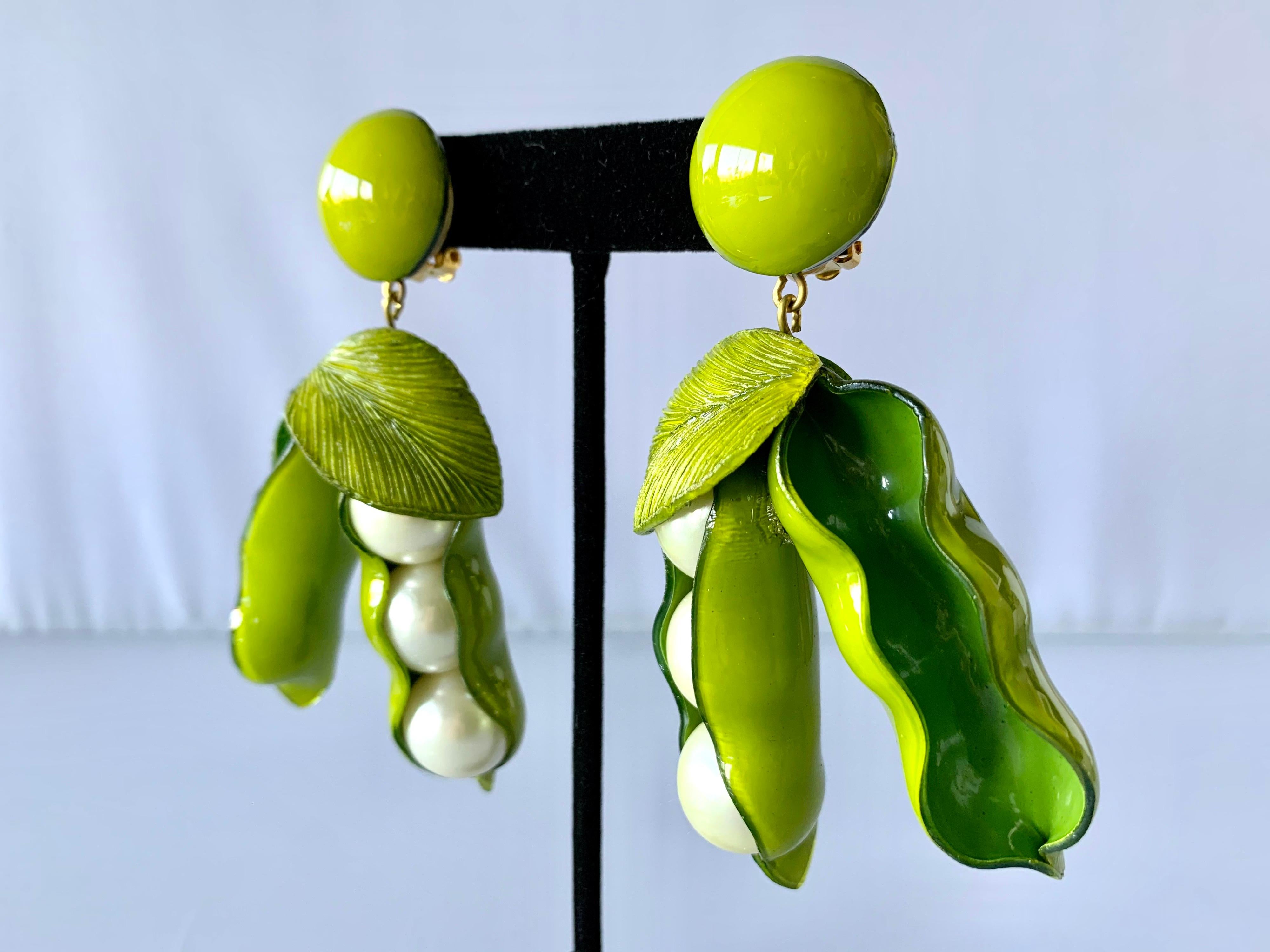 Orecchini a clip artigianali contemporanei realizzati a Parigi in Francia da Cilea Paris - leggeri, caratterizzati da due grandi capsule. I peapodi sono realizzati in resina verde e smalto e hanno grandi perle finte al centro.
