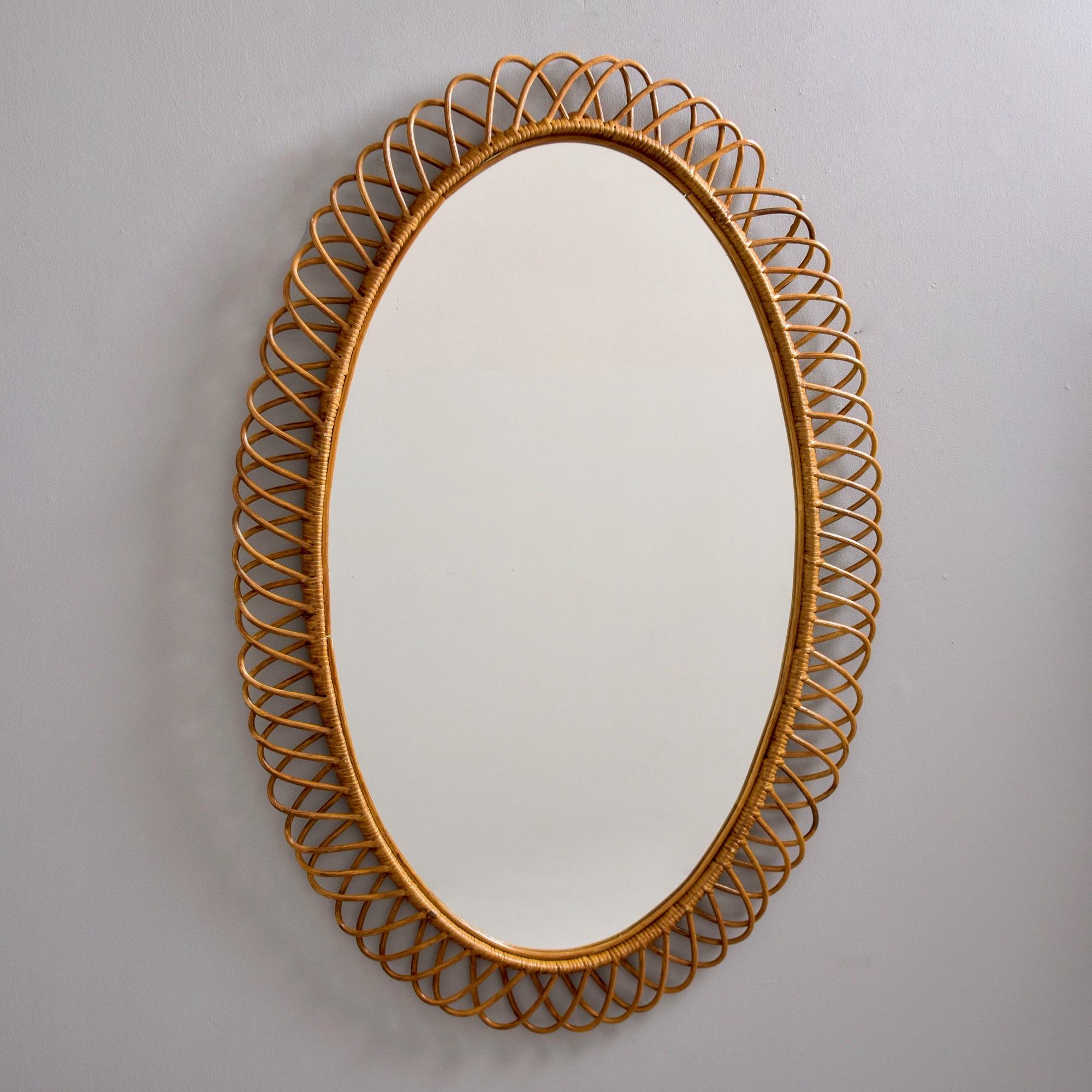 Trovato in Italia, questo specchio ovale extra large con cornice in vimini  risale ai primi anni '70. Questo pezzo è alto 51