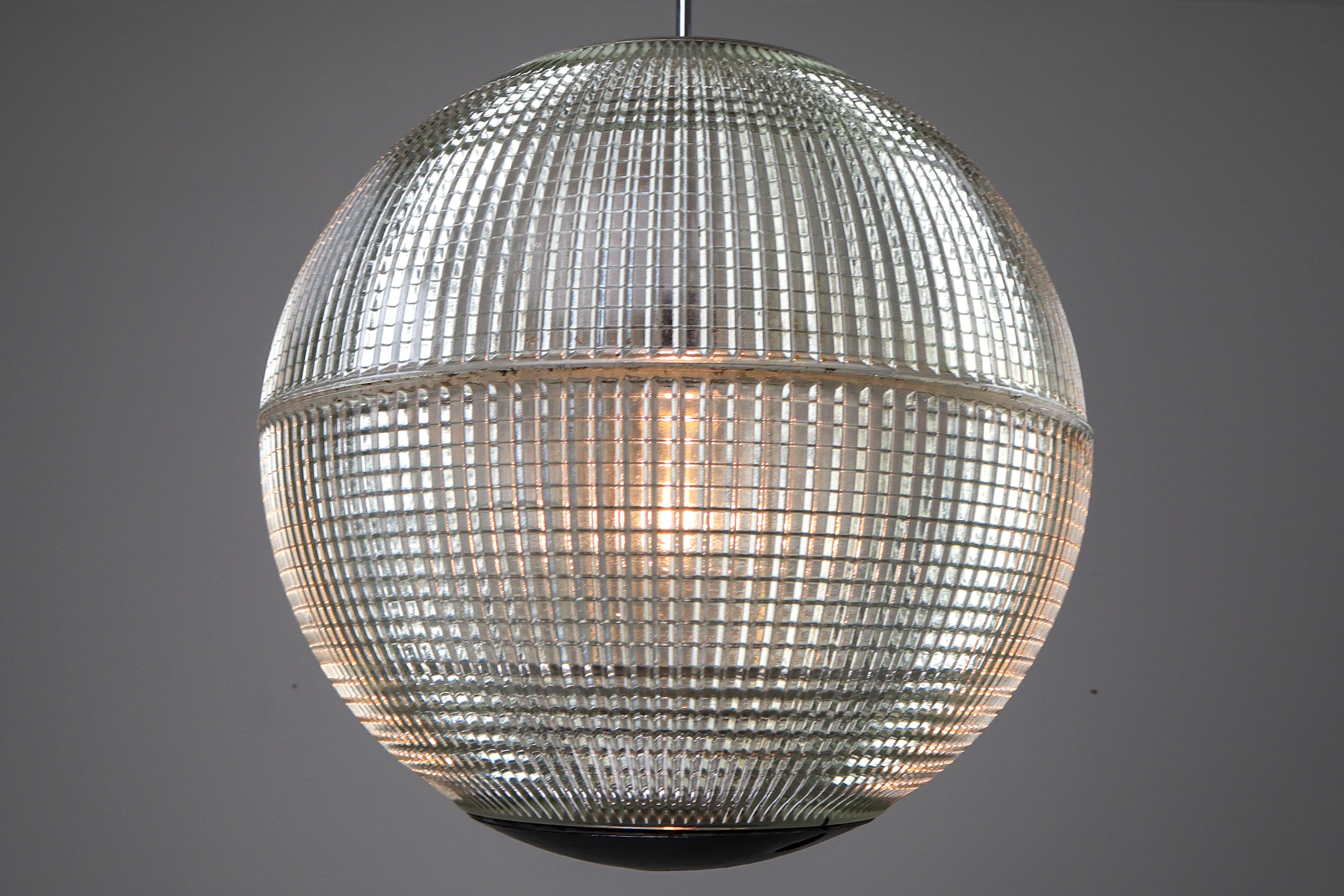 This is a large original late 1960s Paris globe Holophane Street light from Paris, France now turned into a pendant light. The hallmark of Holophane luminaries, or lighting fixtures, is the borosilicate glass reflector / refactor. The glass prisms