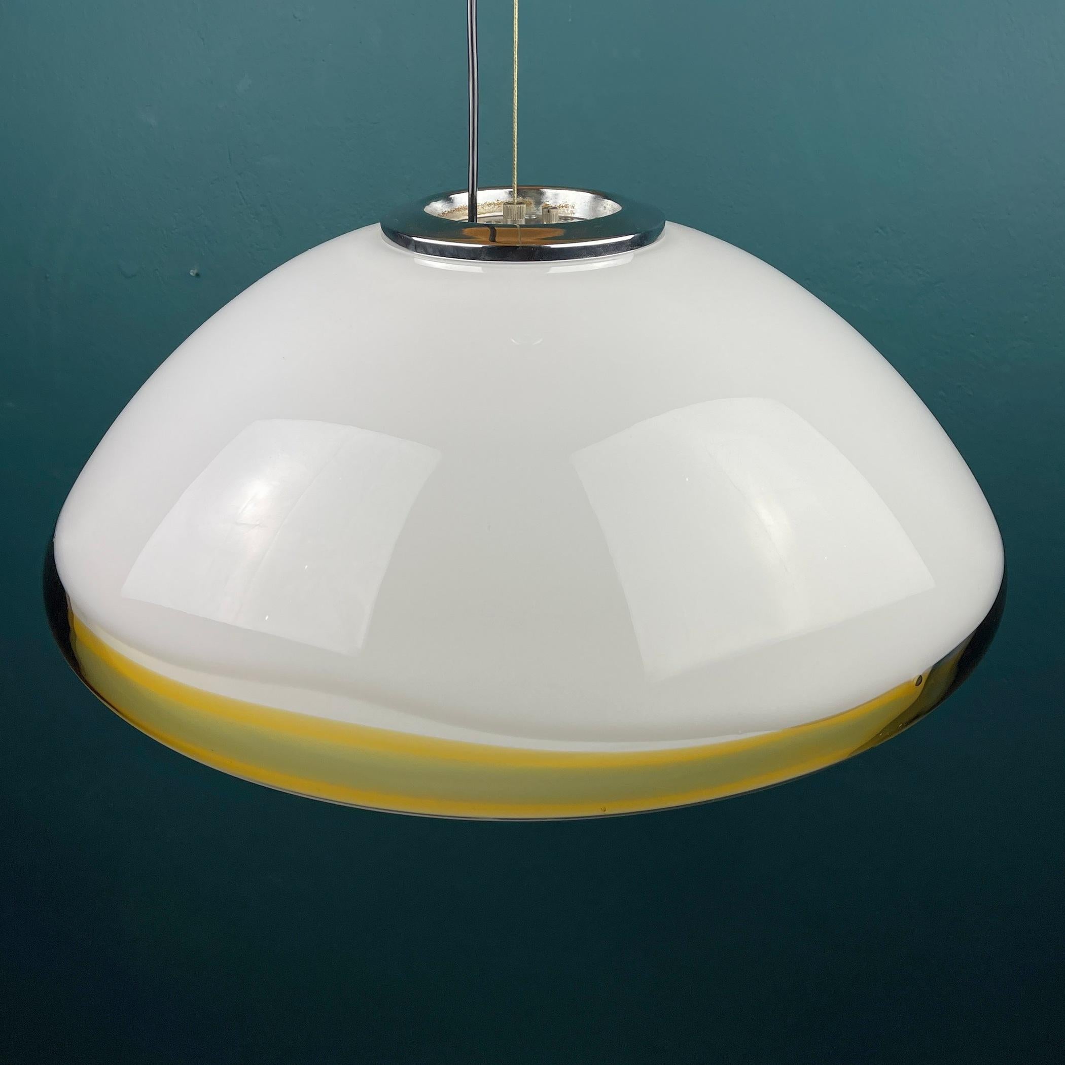 Very unusual vintage large Murano glass pendant lamp made in Italy in the 1970s. The lamp is equipped with a metal base. Milky white glass is beautifully complemented by yellow-green edging. Thanks to the drawing, the lamp creates truly magical