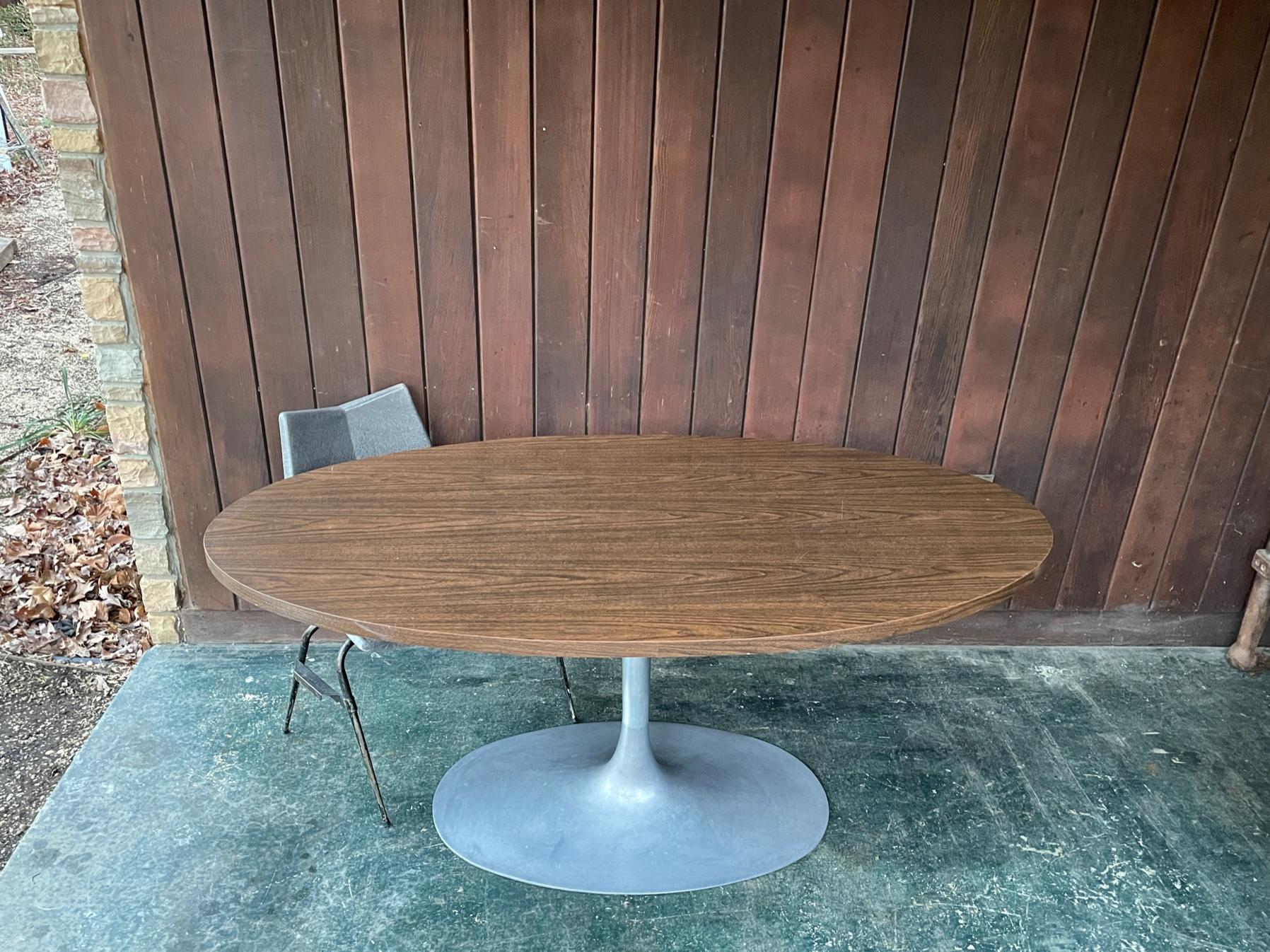 A massive Super Fun Space Age copy of the Eero Saarinen Knoll Tulip dining table. It is designed by Maurice Burke for Arkana. The top surface has some scratches to the formica. A very heavy tabletop. Any chairs are not included in this sale. 