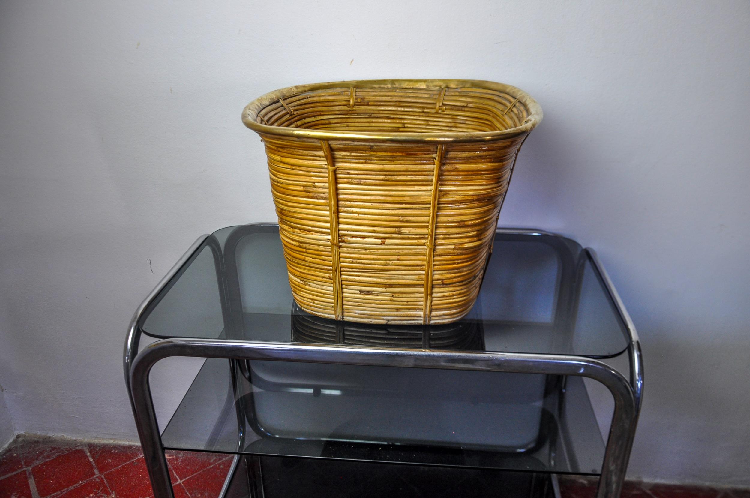 Bellissimo e grande cesto in rattan e ottone realizzato in Italia negli anni Settanta. Dalla forma arrotondata e dallo stile moderno di metà secolo, si ispira agli am designs di Gabriella Crespi. Magnifico oggetto decorativo che darà un vero tocco
