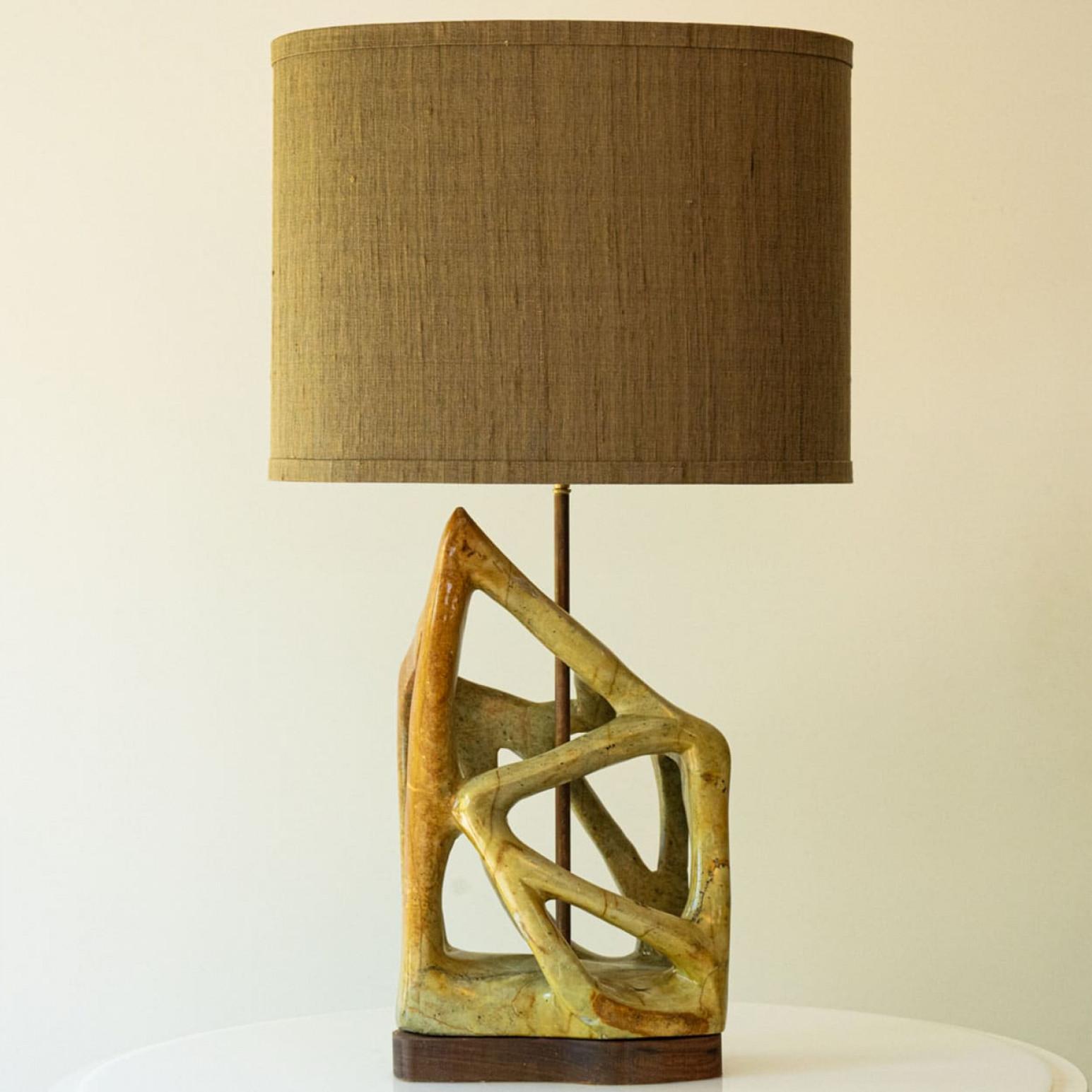 Beautiful serpentine table lamp from the 70s.

This stylish serpentine lamp base on walnut wood brings refined elegance and rich visual appeal to any interior. With its geometric shapes and deep, expressive colors, it showcases the enduring beauty