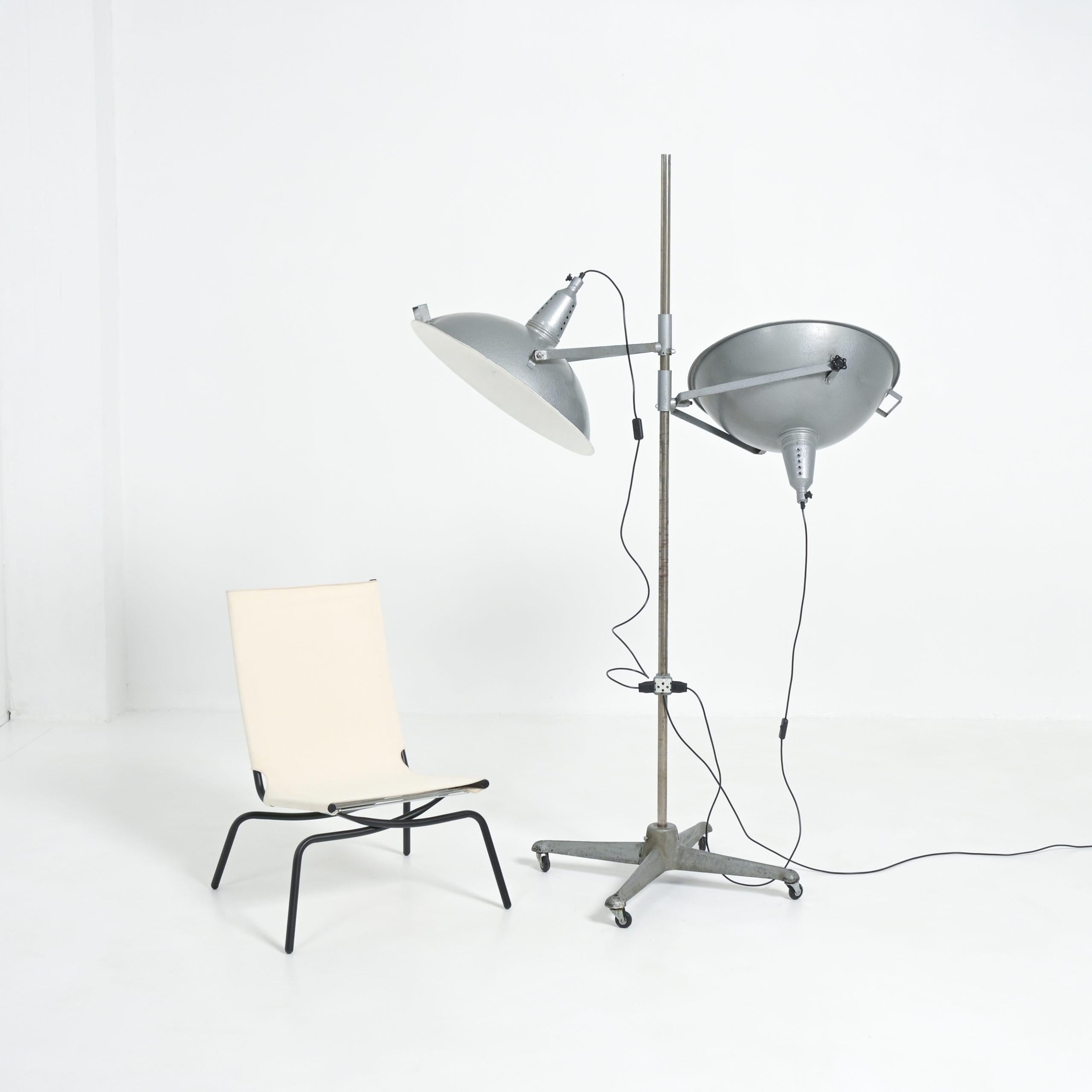 This great studio floor lamp was produced by Narita in Belgium in the 1950s.
This impressive lamp is mobile on its 4 casters. The 2 lampshades (diameter 60 cm) can be rotated in any direction. There is also an extra porcelain outlet on the stem,