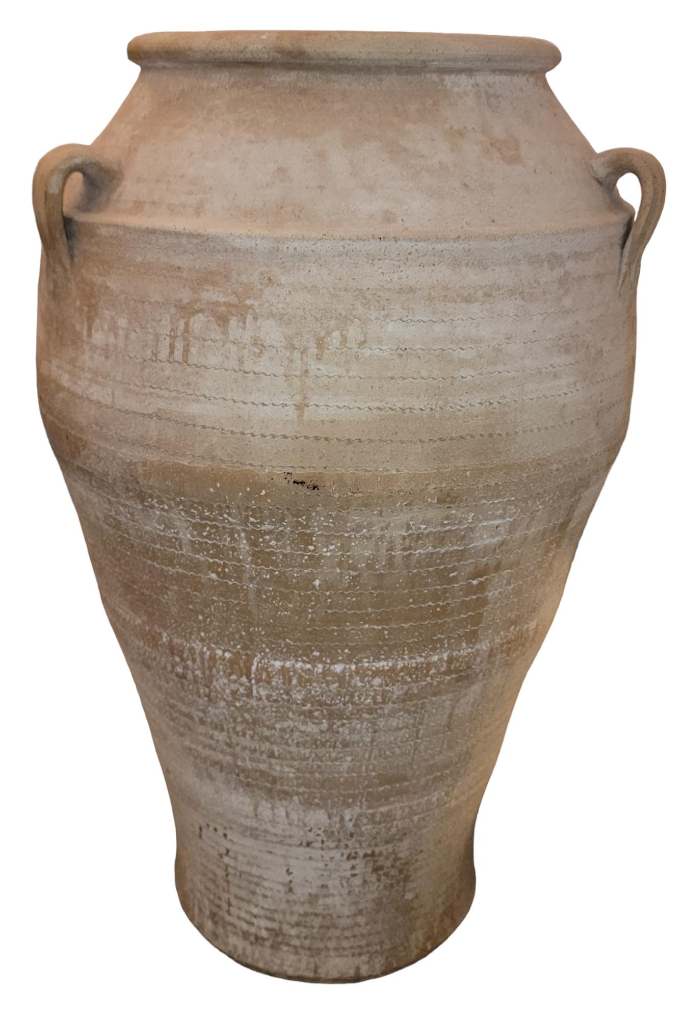 Jarre à olives vintage en poterie grecque avec des poignées et une belle texture au cadre. L'aspect épuré est accentué par les lignes qui font le tour du vase. De superbes poteries faites à la main.

mesure environ - 22 de diamètre x 35,5 de haut.