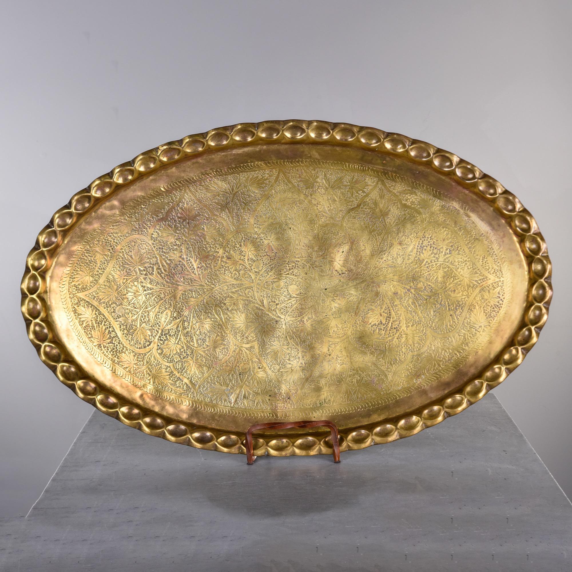Found in the U.S., this circa 1960 extra large oval brass tray was probably used as a table top along with a folding wood base. We do not have a base, and this piece can certainly be used as a tray. Heavy gauge brass has a scalloped edge and overall