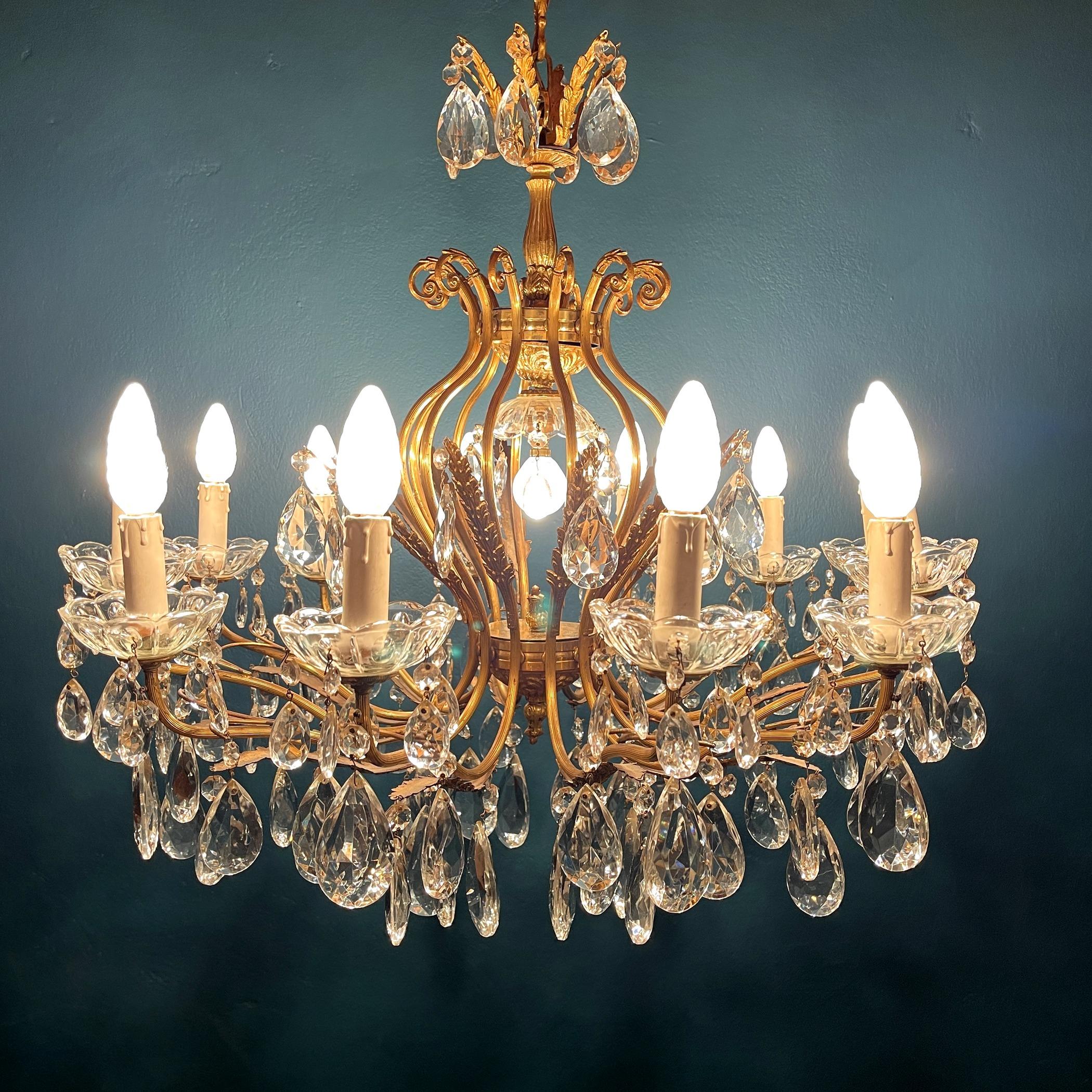 Rare vintage large crystal chandelier made in Italy in the 1950s. The chandelier has 12 solid bronze arms that takes 12 small screw fit light bulb sockets. Electrical wiring checked and replaced by a professional electrician. The chandelier is