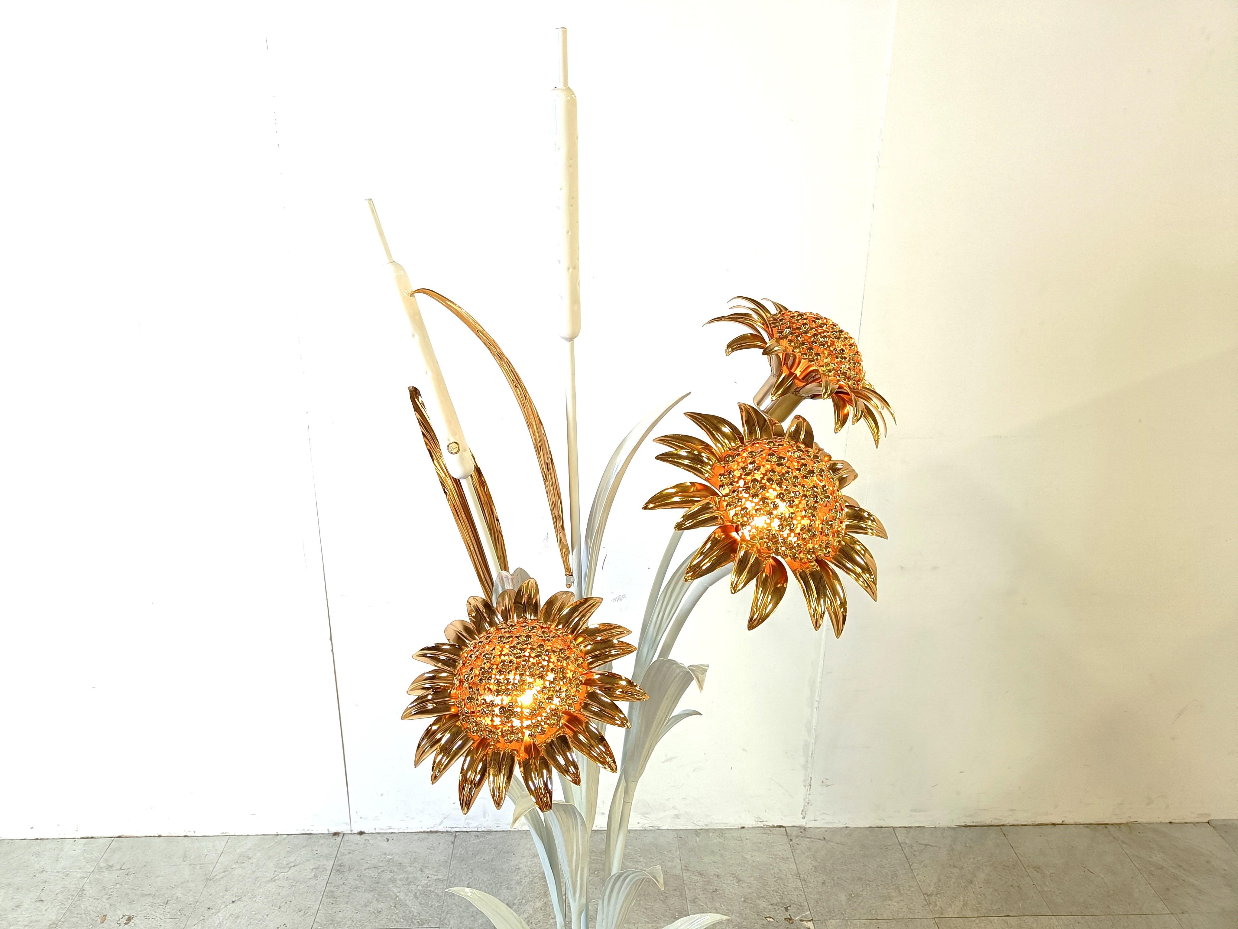 Auffällige und große Stehleuchte von Hans Kögl, bestehend aus einem weiß lackierten Metallsockel mit Weizengarbenmotiv und sehr detaillierten Messingblättern und Sonnenblumen.

Die Sonnenblumen haben integrierte Lichter, die einen fantastischen