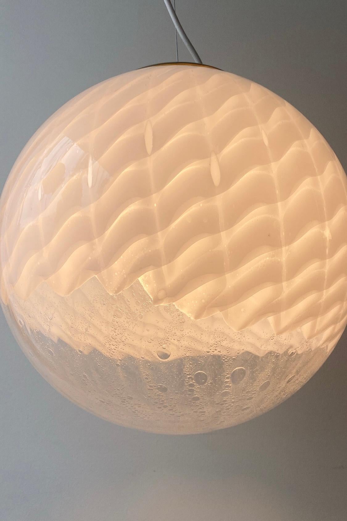 Fantastically beautiful Murano ceiling lamp in white and transparent mouth-blown glass with new hand molded brass suspension. The glass is mouth-blown in a round shape with fine bubbles and pattern. Handmade in Italy, 1970s. 
D: 40 cm.